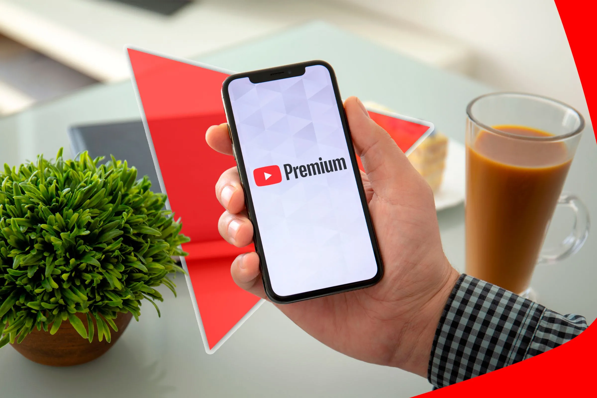 Bàn tay cầm điện thoại có logo Youtube Premium trên màn hình.