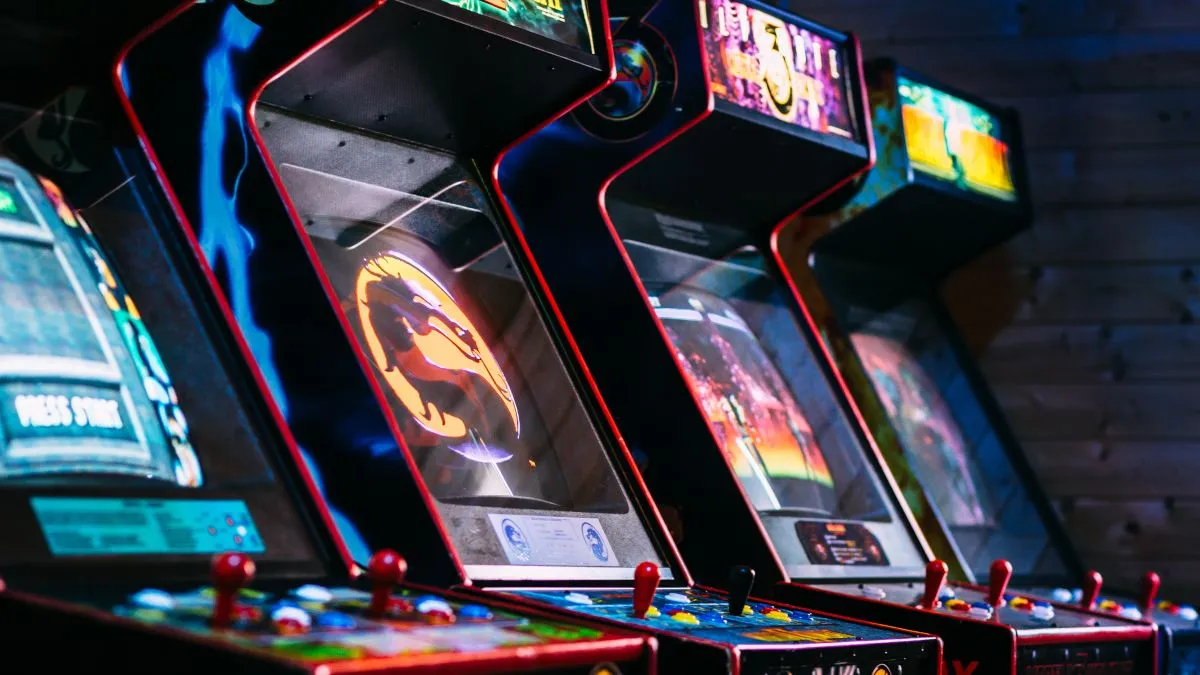 Bộ sưu tập các máy arcade cổ điển trong một căn phòng tối.