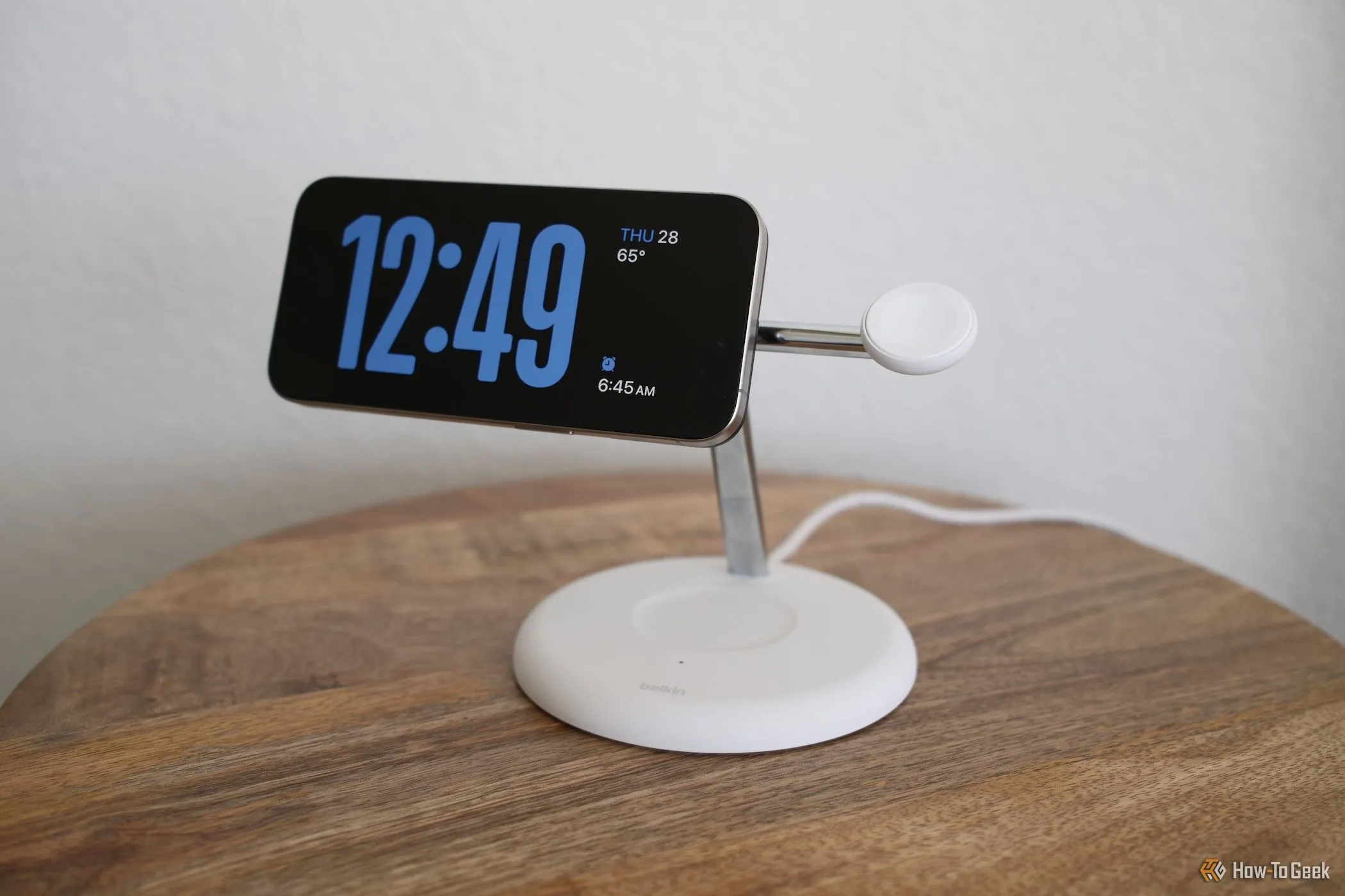 iPhone hiển thị chế độ StandBy trên đế sạc không dây Belkin BoostCharge Pro với công nghệ Qi2, thể hiện khả năng sạc và hiển thị tiện lợi.