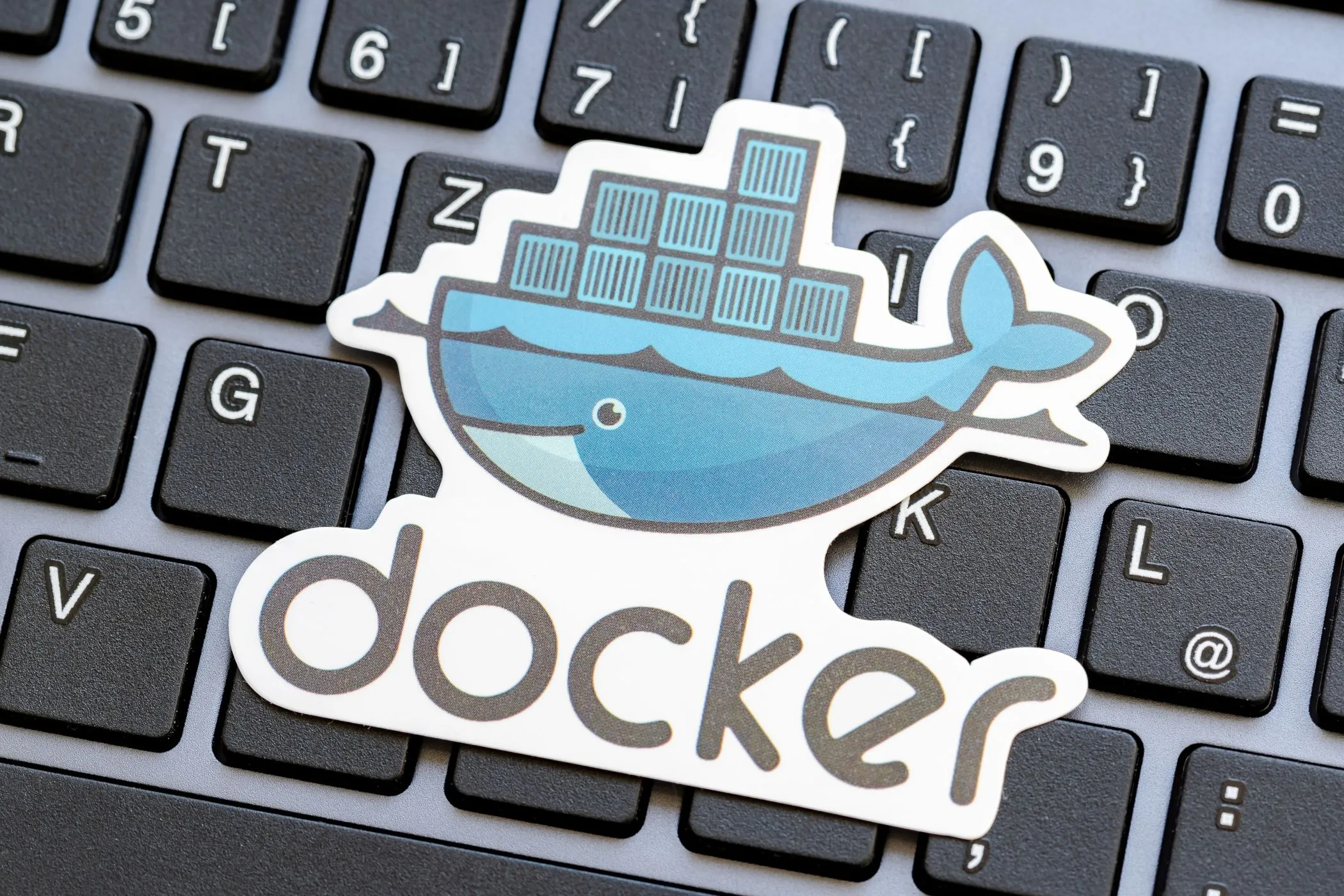 Logo Docker đặt trên bàn phím laptop, minh họa việc sử dụng Docker để cài đặt Syncthing trên môi trường Unraid.