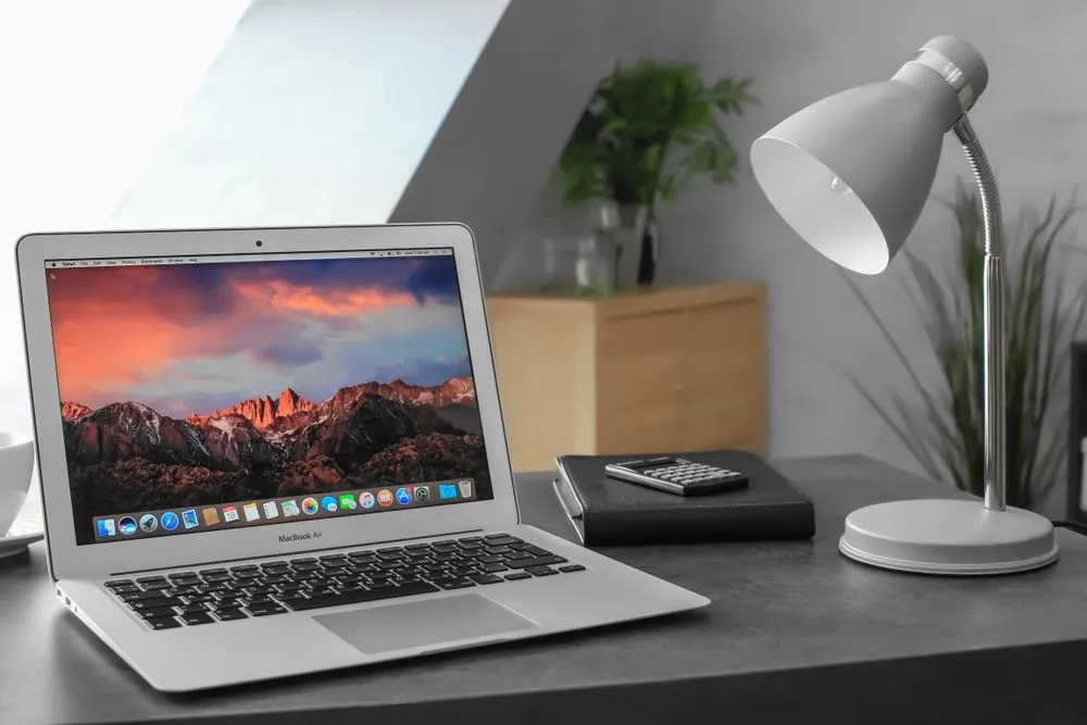 MacBook Air 2017 màu bạc với màn hình desktop, cho thấy thiết kế đã cũ và màn hình TN độ phân giải thấp của dòng máy này.