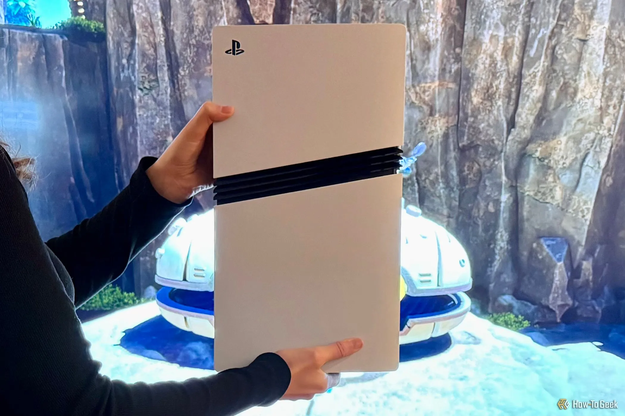 Máy chơi game PlayStation 5 Pro được cầm trên tay trước màn hình TV lớn.