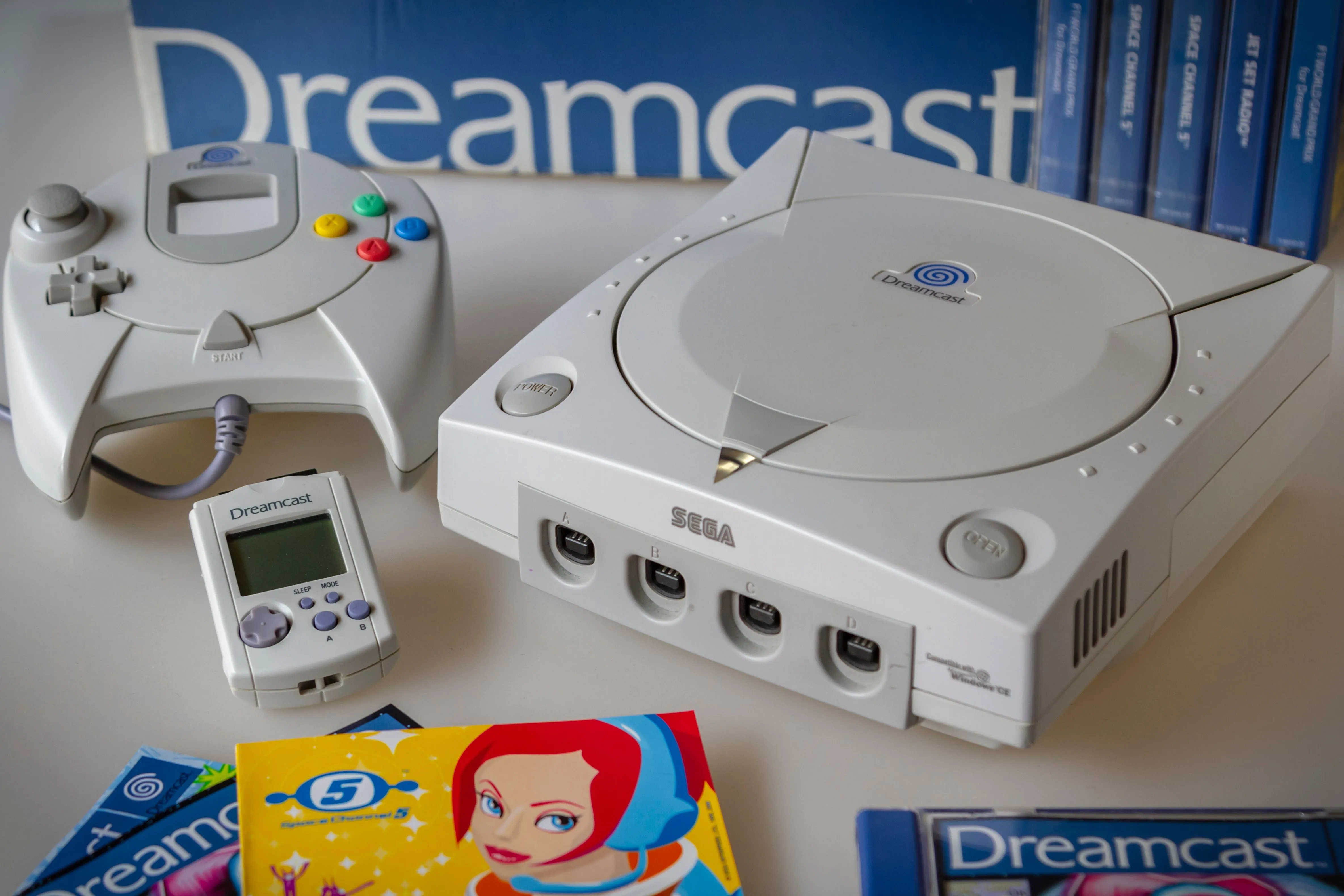 Máy chơi game Sega Dreamcast cùng tay cầm, thiết bị lưu trữ VMU và tựa game Space Channel 5, minh họa vẻ đẹp cổ điển của console.