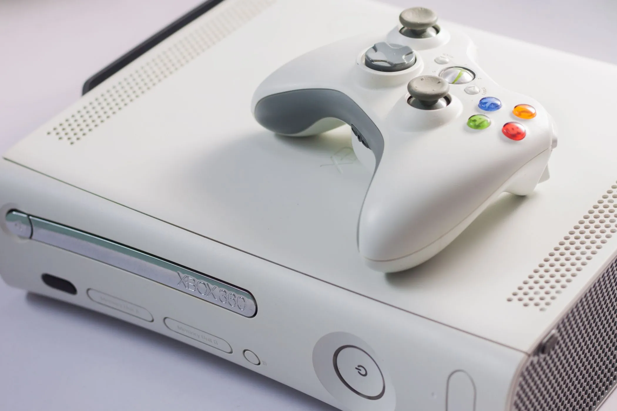 Máy console Xbox 360 màu trắng cùng một tay cầm, biểu tượng của thời kỳ vàng son của Xbox.