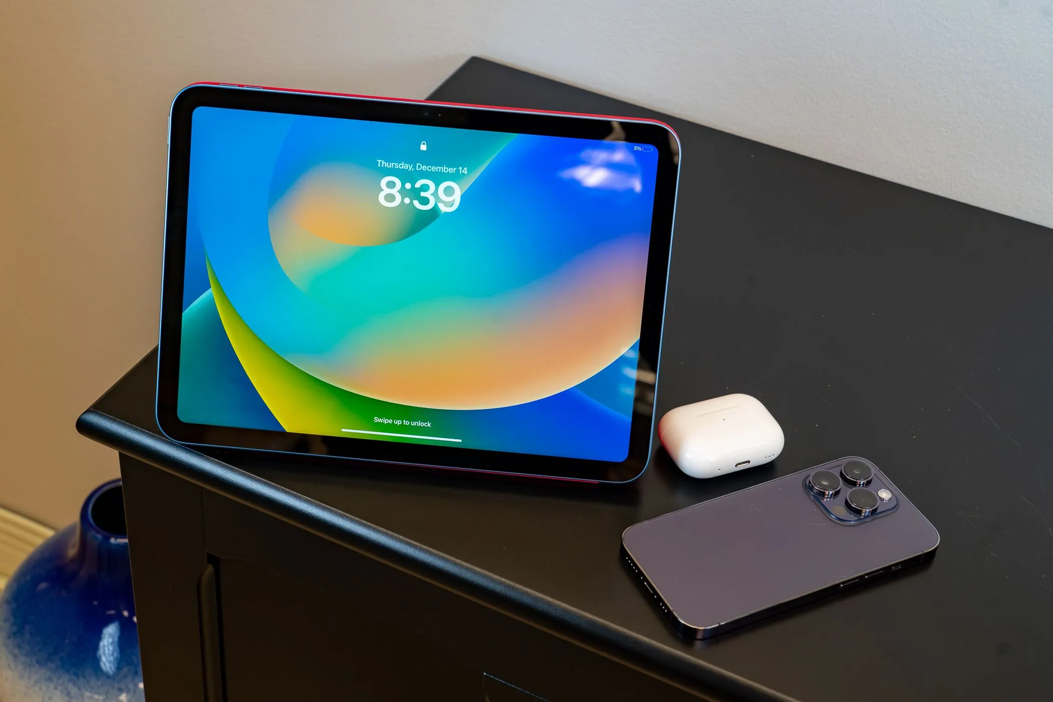 Một chiếc iPad đặt cạnh AirPods và iPhone, minh họa hệ sinh thái di động của Apple