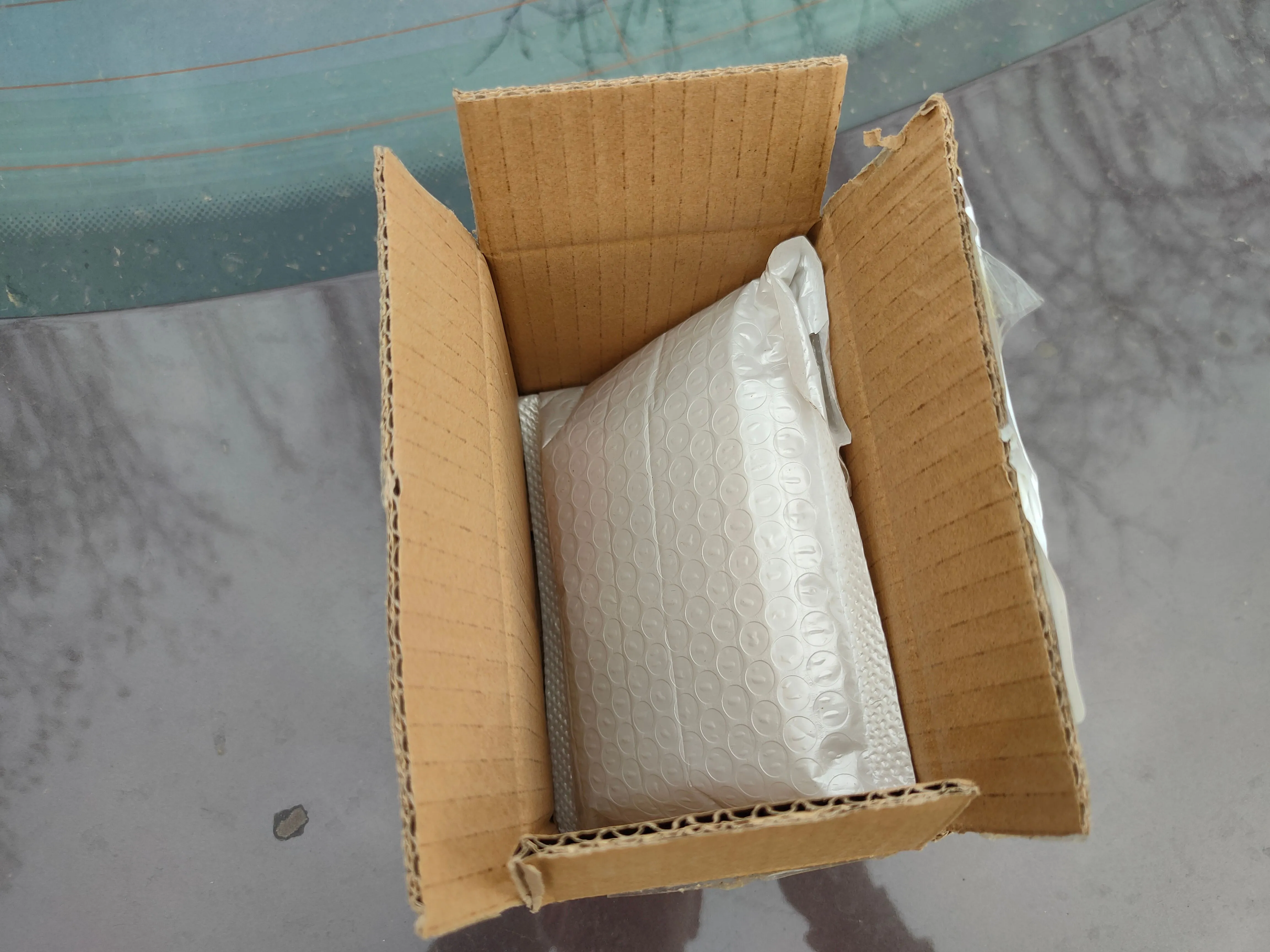 Một gói hàng bọc bong bóng khí chứa CPU được đặt trong hộp carton màu nâu, sẵn sàng để gửi trả.