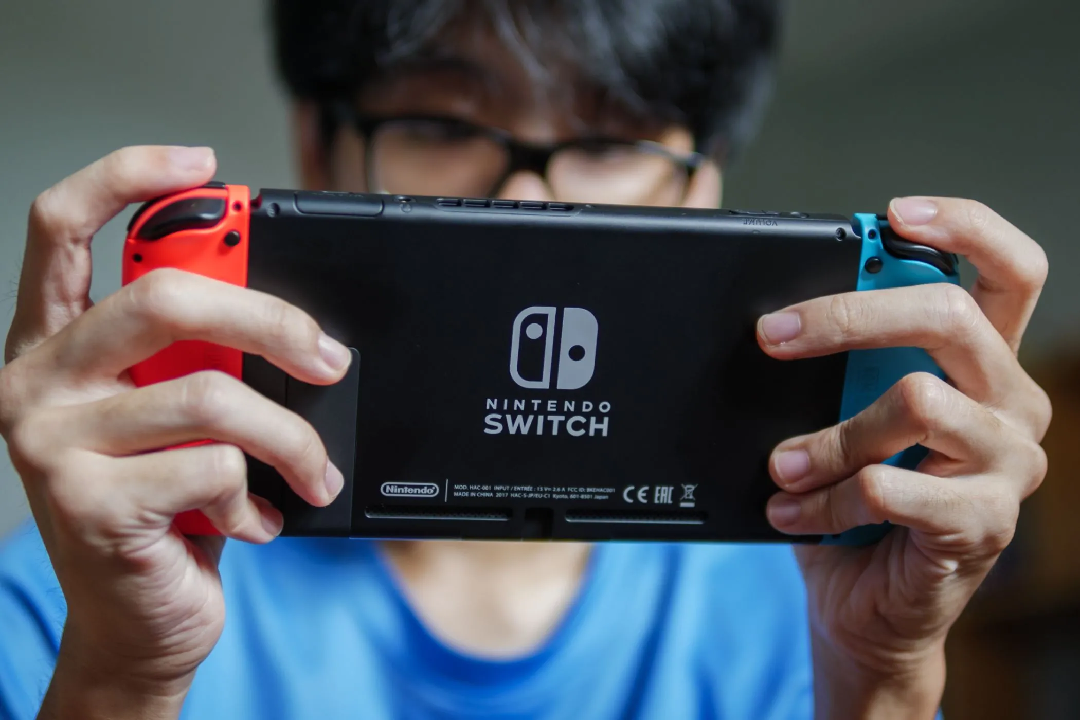 Một người đàn ông đang chơi Nintendo Switch ở chế độ cầm tay.