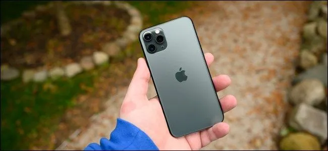Người dùng cầm điện thoại iPhone 11 Pro, biểu tượng cho các dòng iPhone hỗ trợ sạc không dây Qi