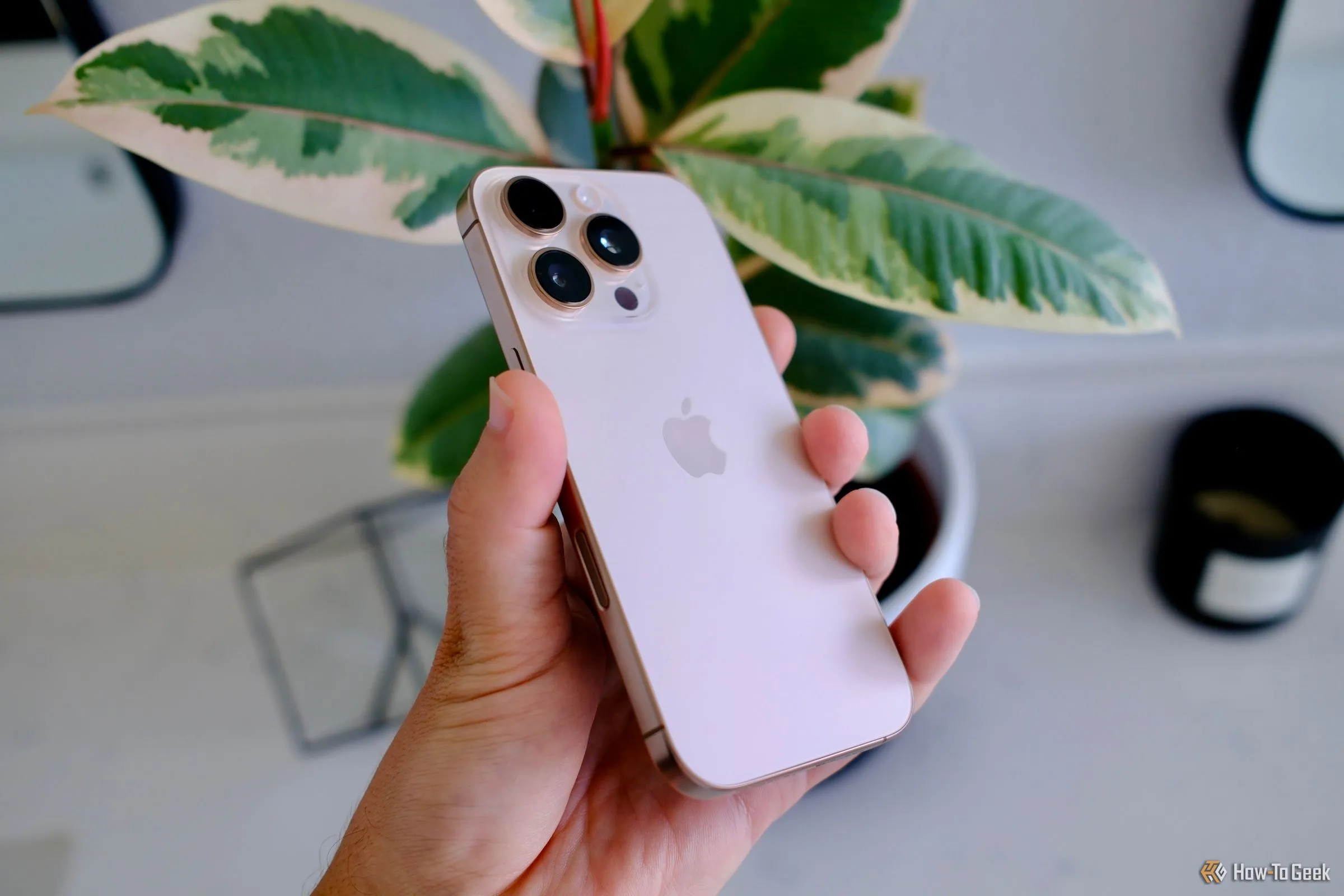 Người dùng đang cầm điện thoại iPhone 16 Pro với giao diện ứng dụng quản lý tài chính