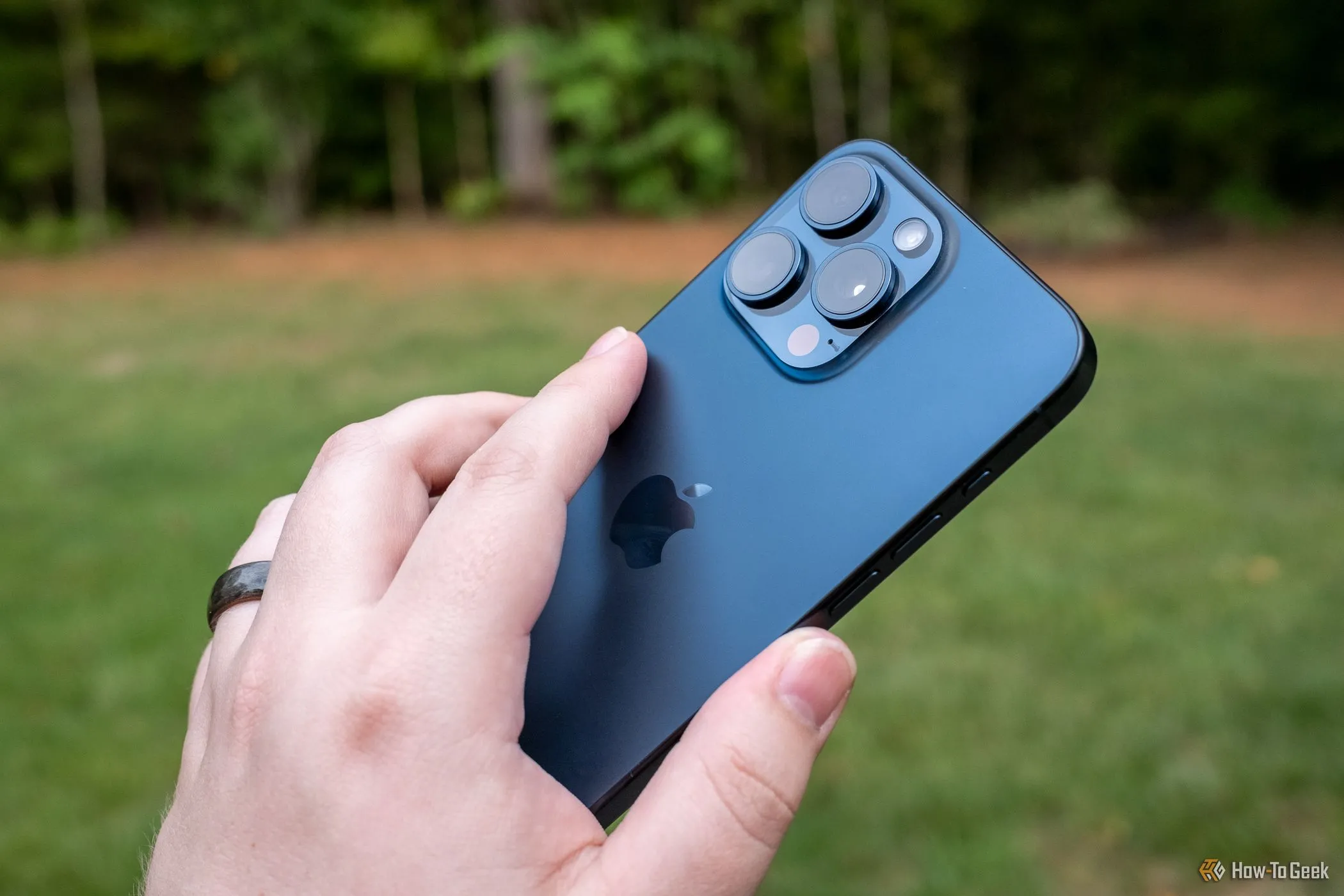 Người dùng đang chạm vào mặt lưng iPhone 15 Pro Max để kích hoạt cử chỉ Back Tap