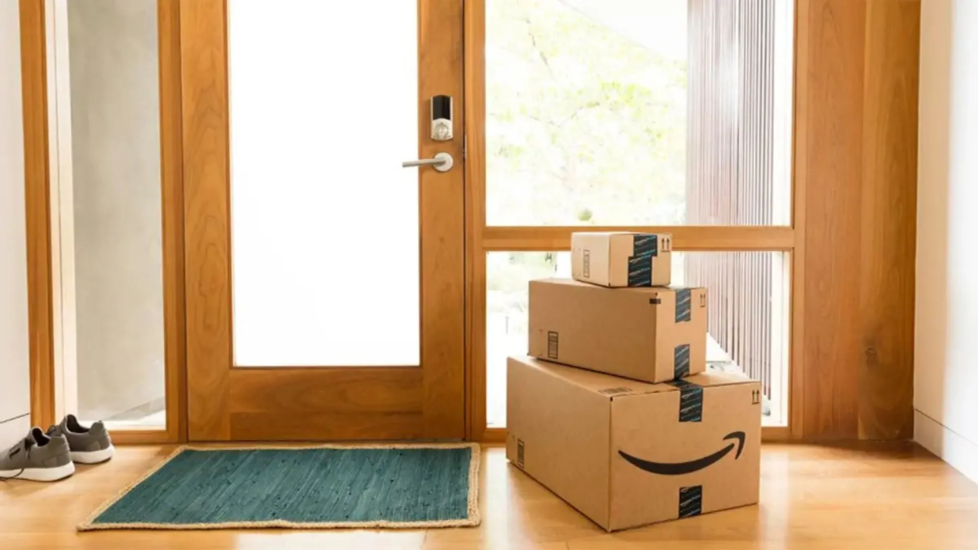 Những hộp hàng Amazon đặt trước cửa, tượng trưng cho việc mua sắm và trả hàng trực tuyến.