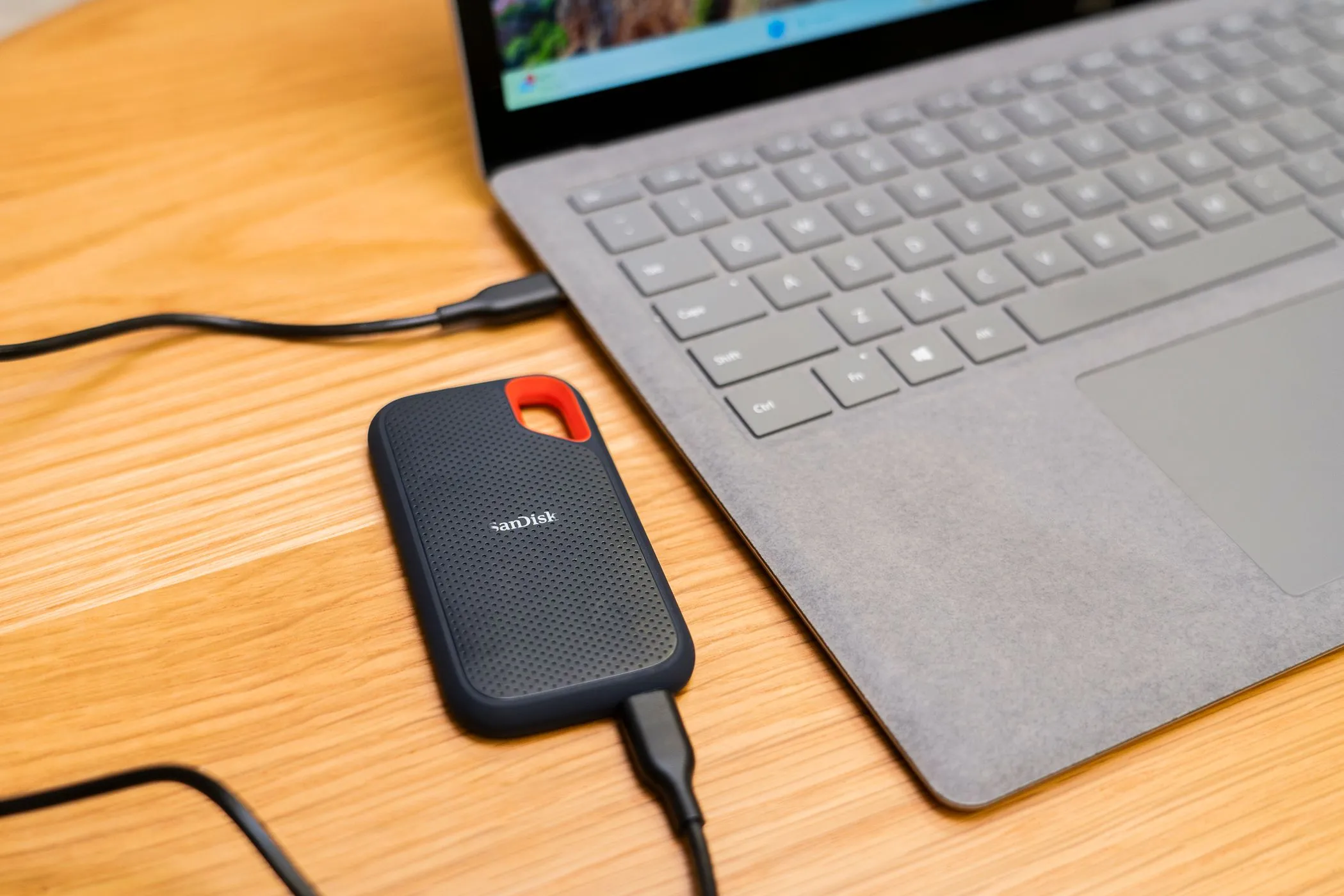 Ổ SSD gắn ngoài kết nối với laptop, minh họa sự tiện lợi khi sao lưu dữ liệu.
