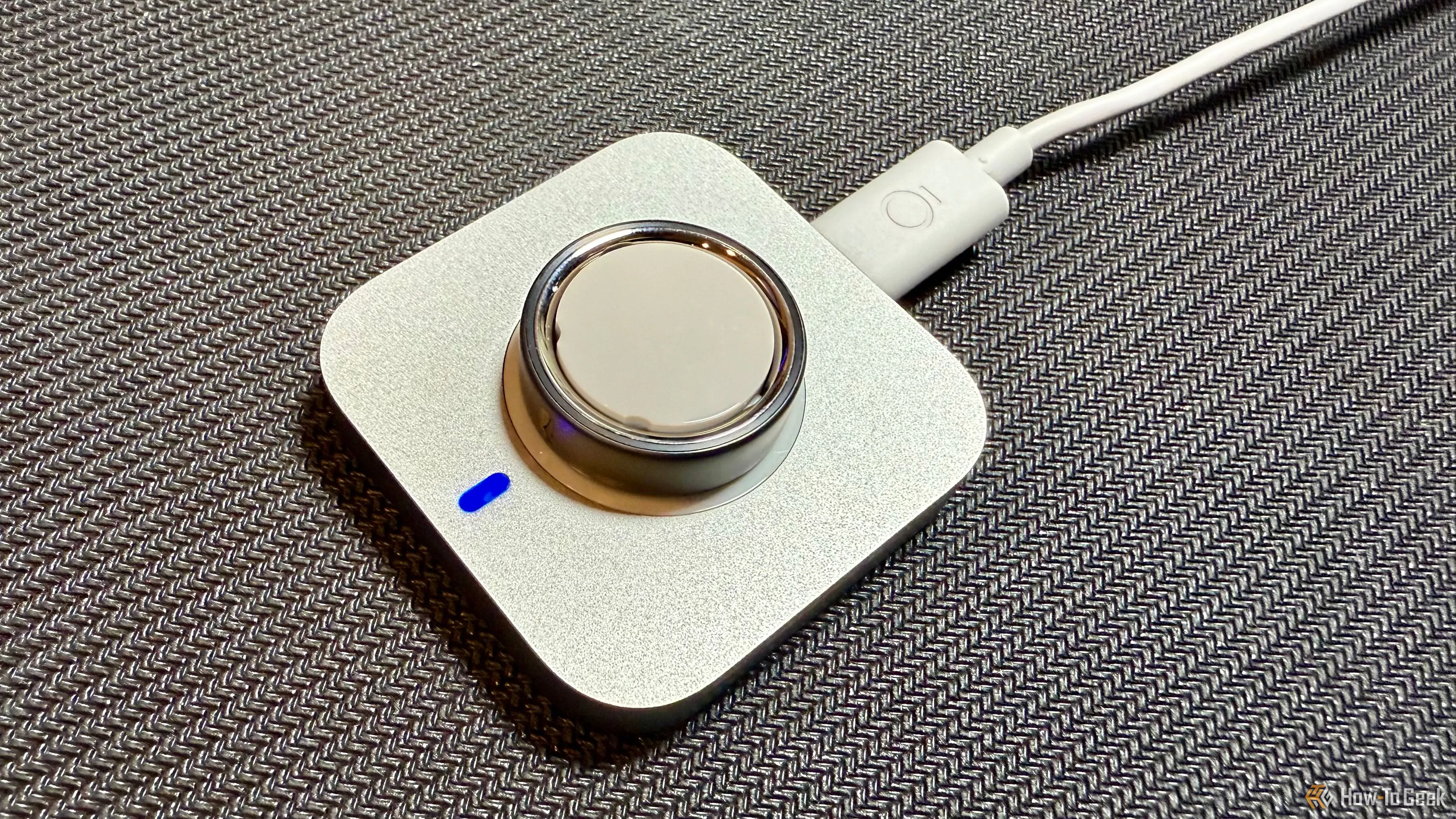 Oura Ring 4 đang sạc trên đế sạc