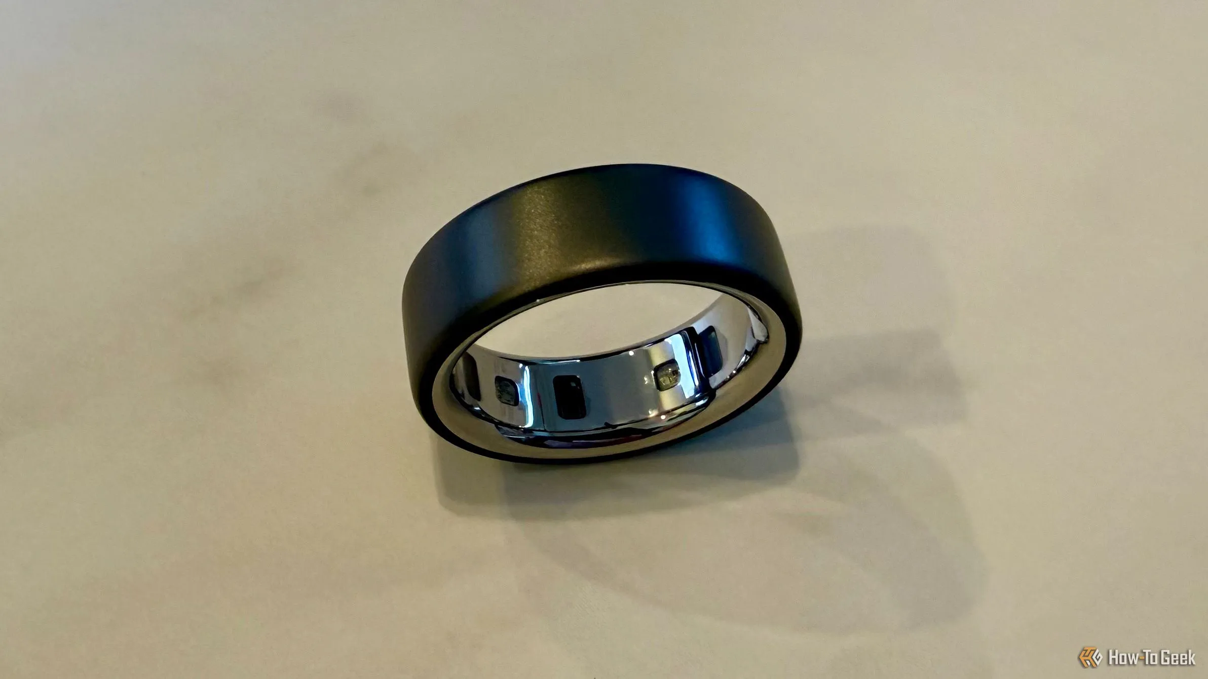 Oura Ring 4 đặt trên bàn, cho thấy các cảm biến bên trong