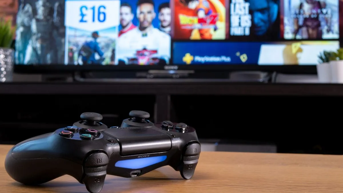 Tay cầm Sony Dualshock 4 của PlayStation trước màn hình TV hiển thị cửa hàng PlayStation Store, minh họa bối cảnh game kỹ thuật số.