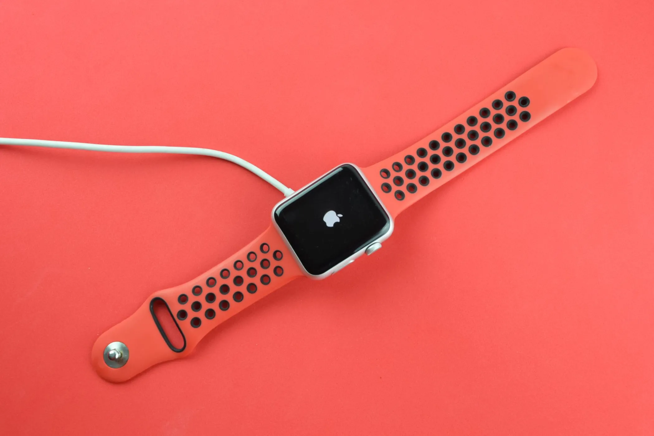Apple Watch đang sạc hiển thị logo Apple, biểu tượng của sự kết nối liên tục.