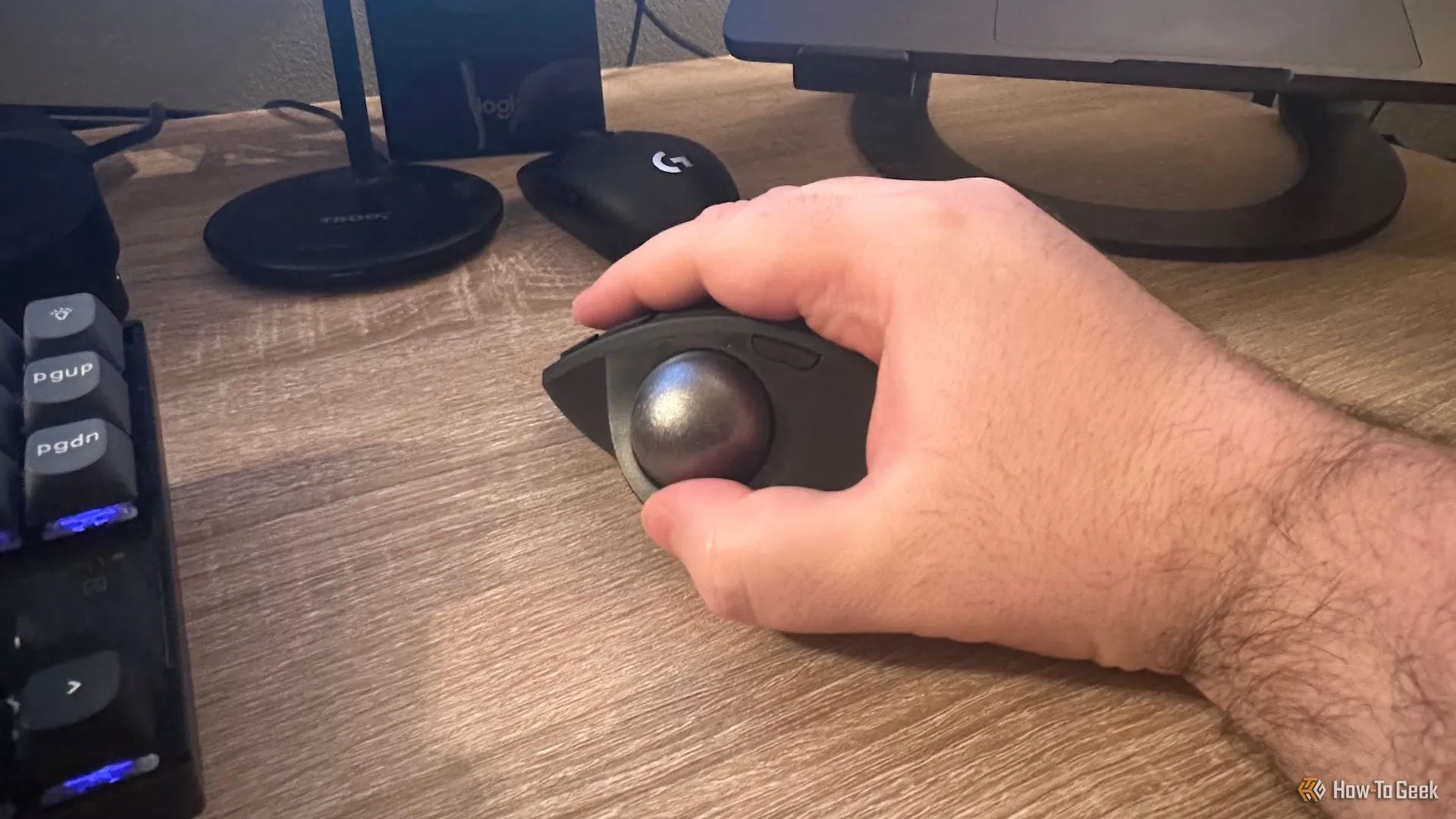 Bàn tay người dùng đang cầm chuột Logitech MX Ergo S, minh họa tư thế cầm thoải mái và thiết kế công thái học.