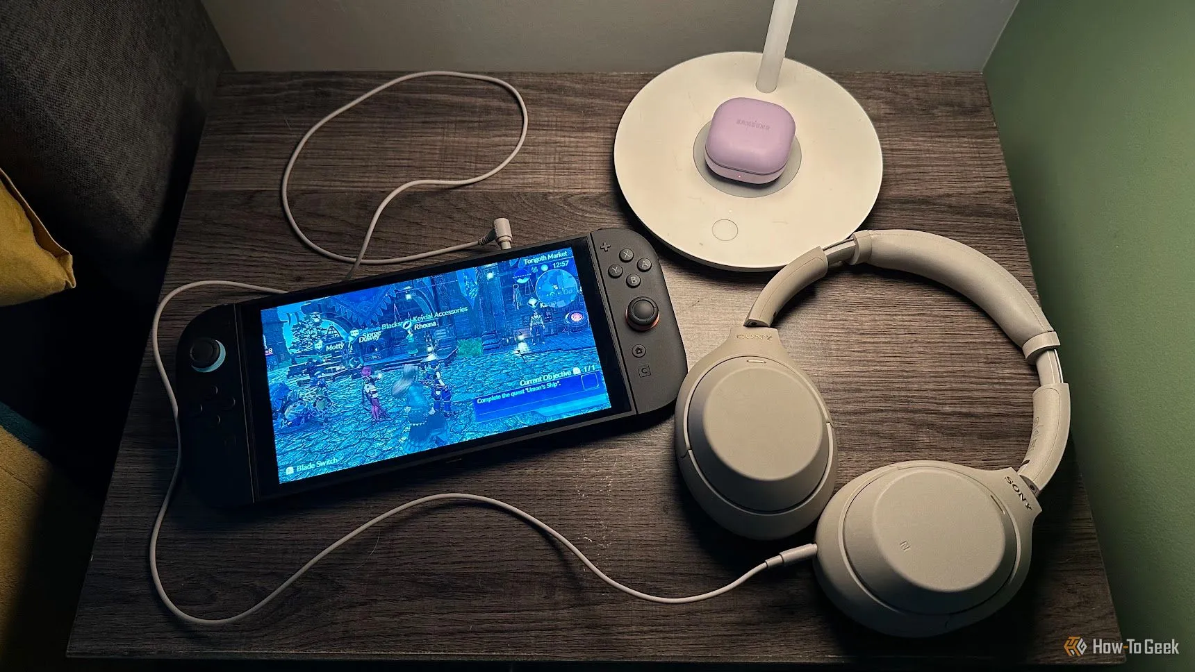 Bộ đôi hoàn hảo: Nintendo Switch 2 và tai nghe Sony WH-1000XM cùng bộ điều khiển đặt trên bàn cạnh giường ngủ