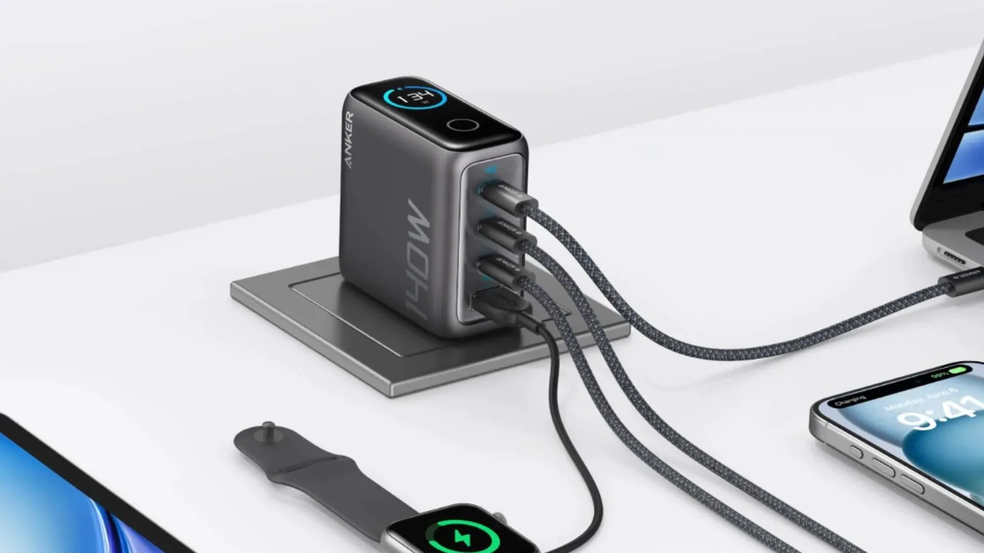 Bộ sạc Anker 140W với thiết kế cổng dưới đang cắm vào ổ điện trên tường và kết nối với các thiết bị, thể hiện sự gọn gàng.