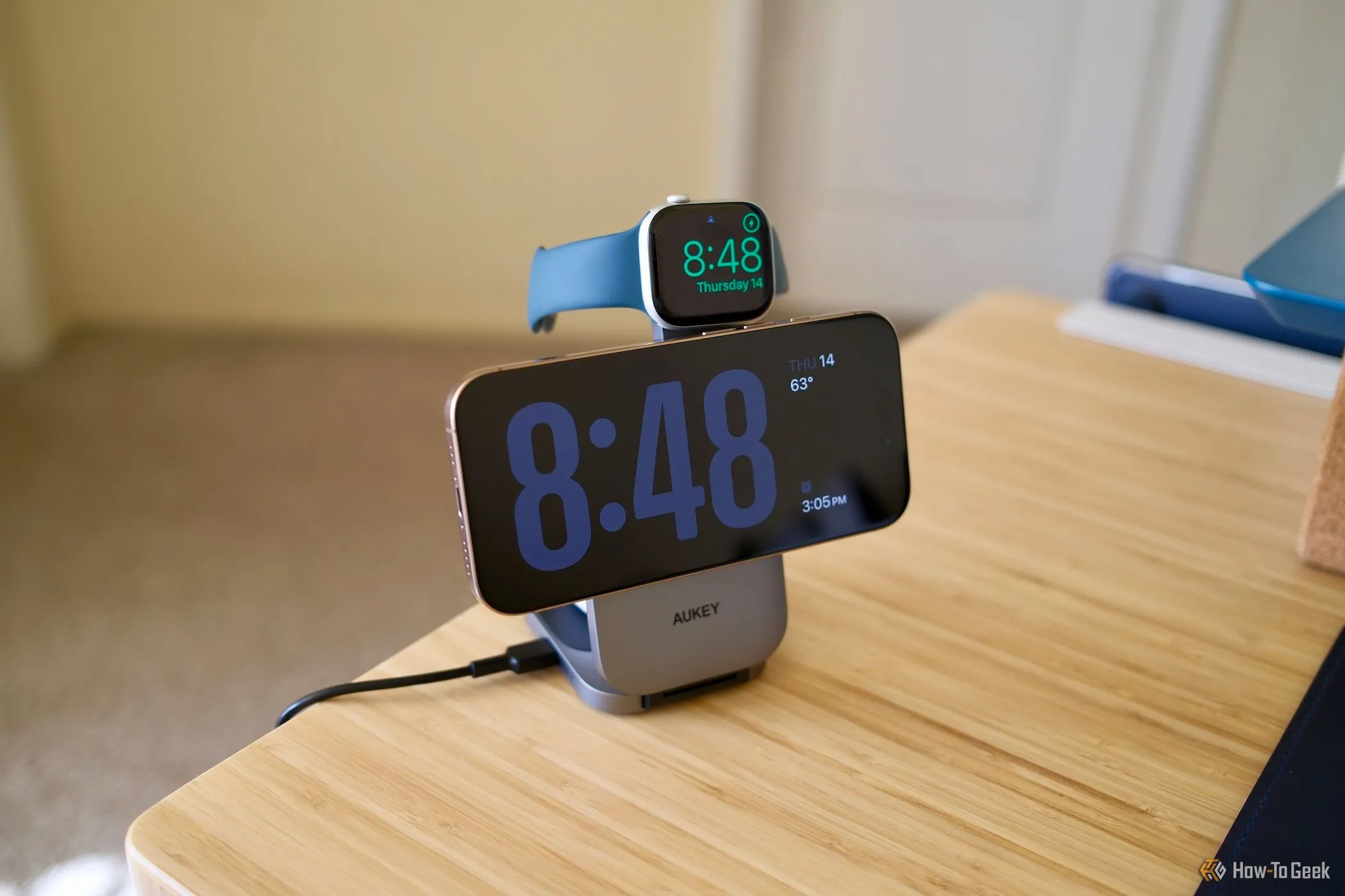 Bộ sạc không dây Aukey MagFusion Z đang sạc cùng lúc iPhone và Apple Watch, thể hiện sự tiện lợi khi sạc đa thiết bị.