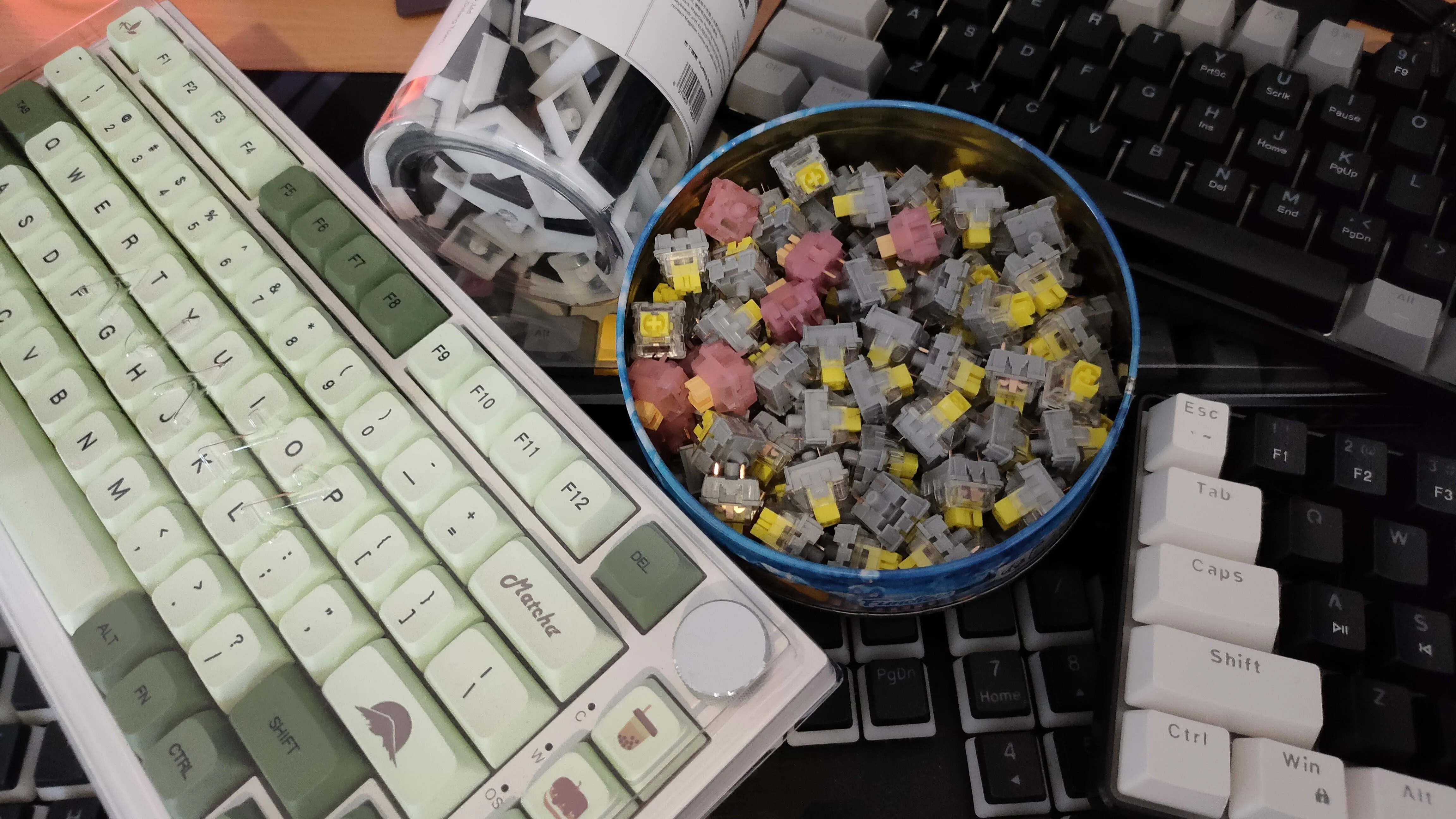 Bộ sưu tập bàn phím, switch và keycap từ Temu được sắp xếp trên bàn làm việc, thể hiện sự đa dạng trong tùy chỉnh bàn phím cơ