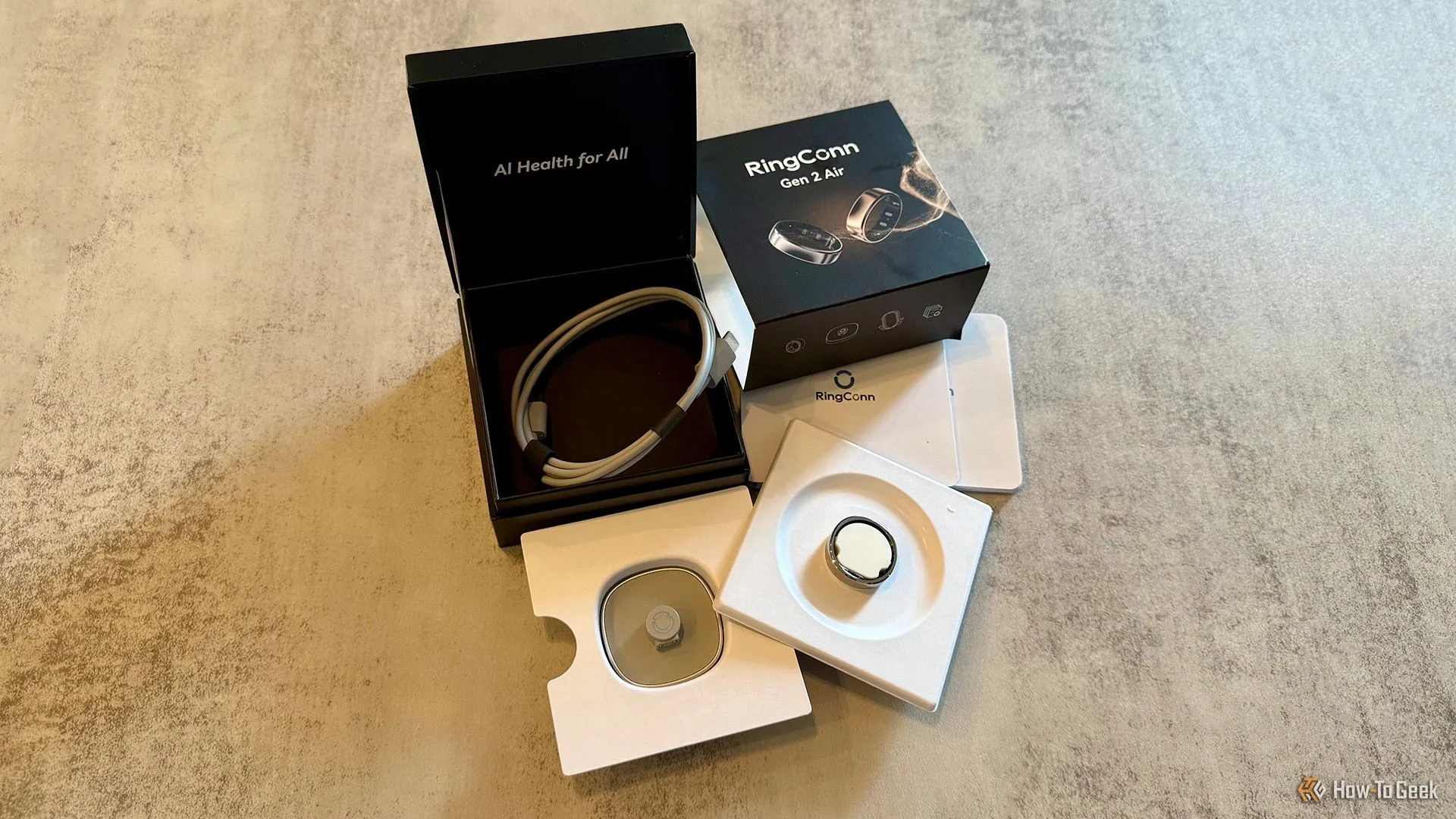 Các thành phần bên trong hộp RingConn Gen 2 Air, bao gồm nhẫn thông minh, đế sạc không dây và cáp sạc USB-C.