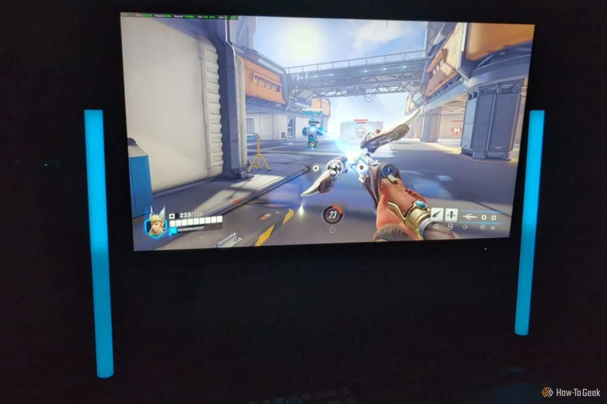 Cảnh chơi game Overwatch 2 với nhân vật Mercy đang hồi máu cho đồng đội, cùng với ánh sáng từ phụ kiện Razer Aether phản ứng theo game