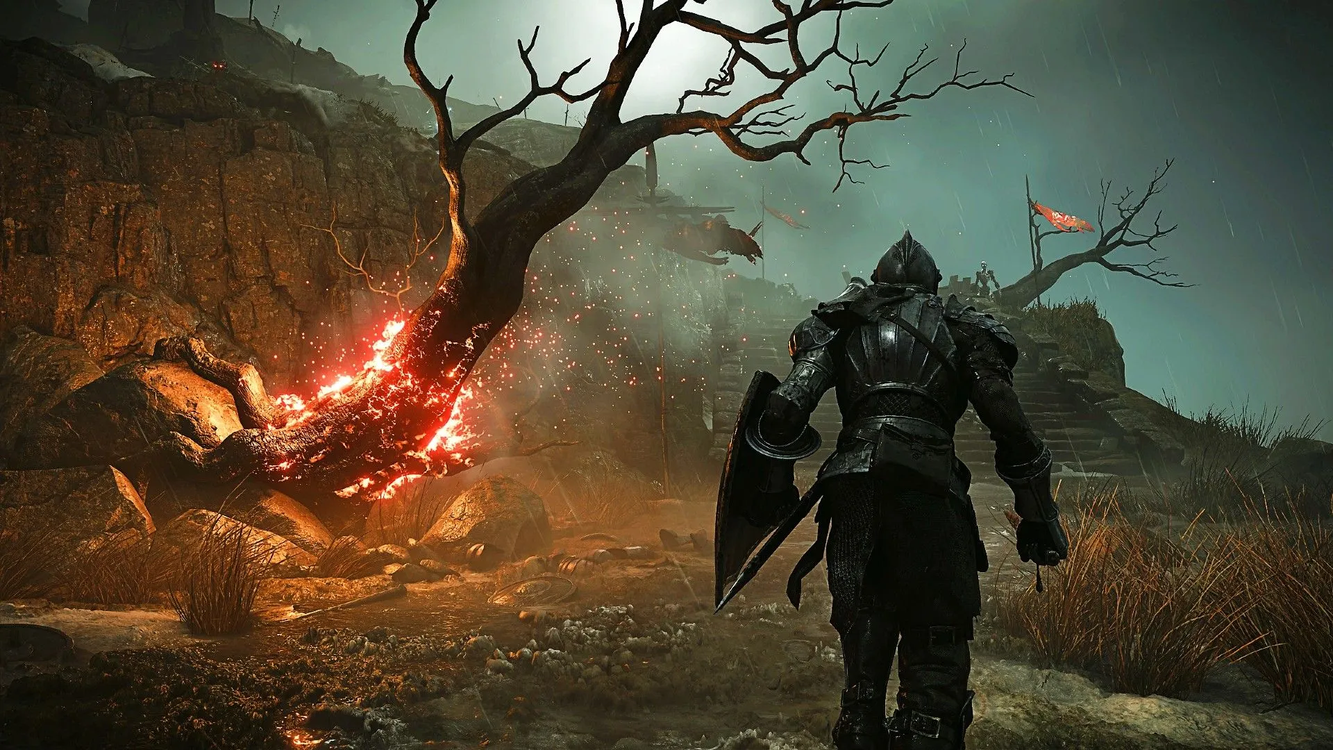 Cảnh trong game Demon's Souls Remake cho thấy người chơi đi bộ cạnh một cái cây đang cháy tại khu vực Shrine of Storms.