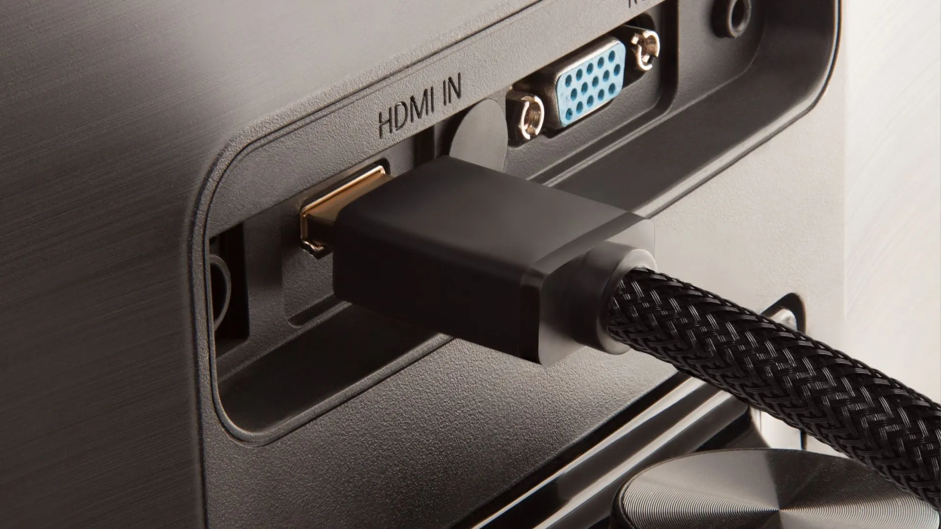 Cáp HDMI được cắm vào mặt sau của màn hình, minh họa việc lựa chọn đúng cổng kết nối để tối ưu hiệu suất hiển thị.