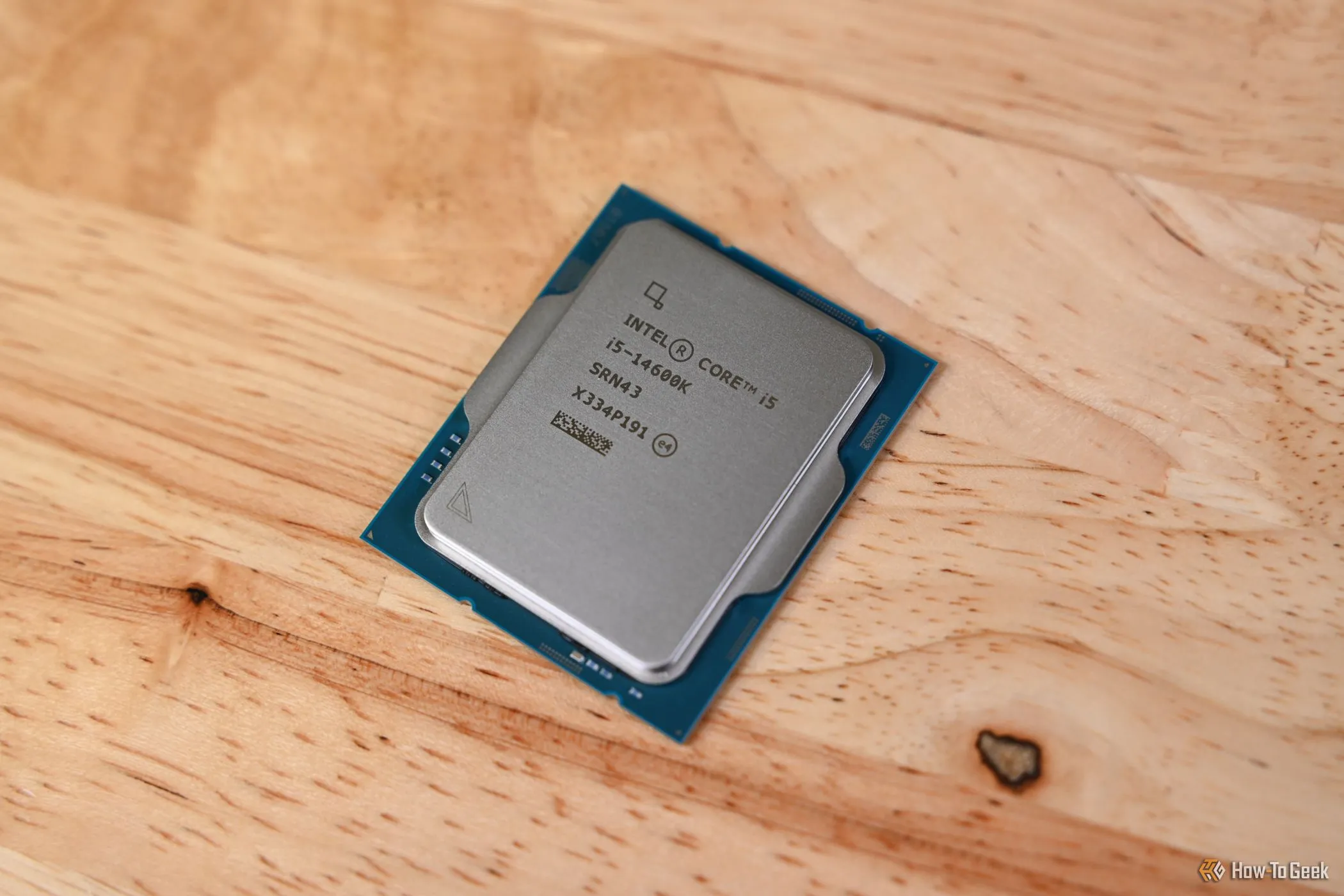 CPU Intel Core i5-14600K màu bạc được đặt trên một bề mặt phẳng có bóng đổ