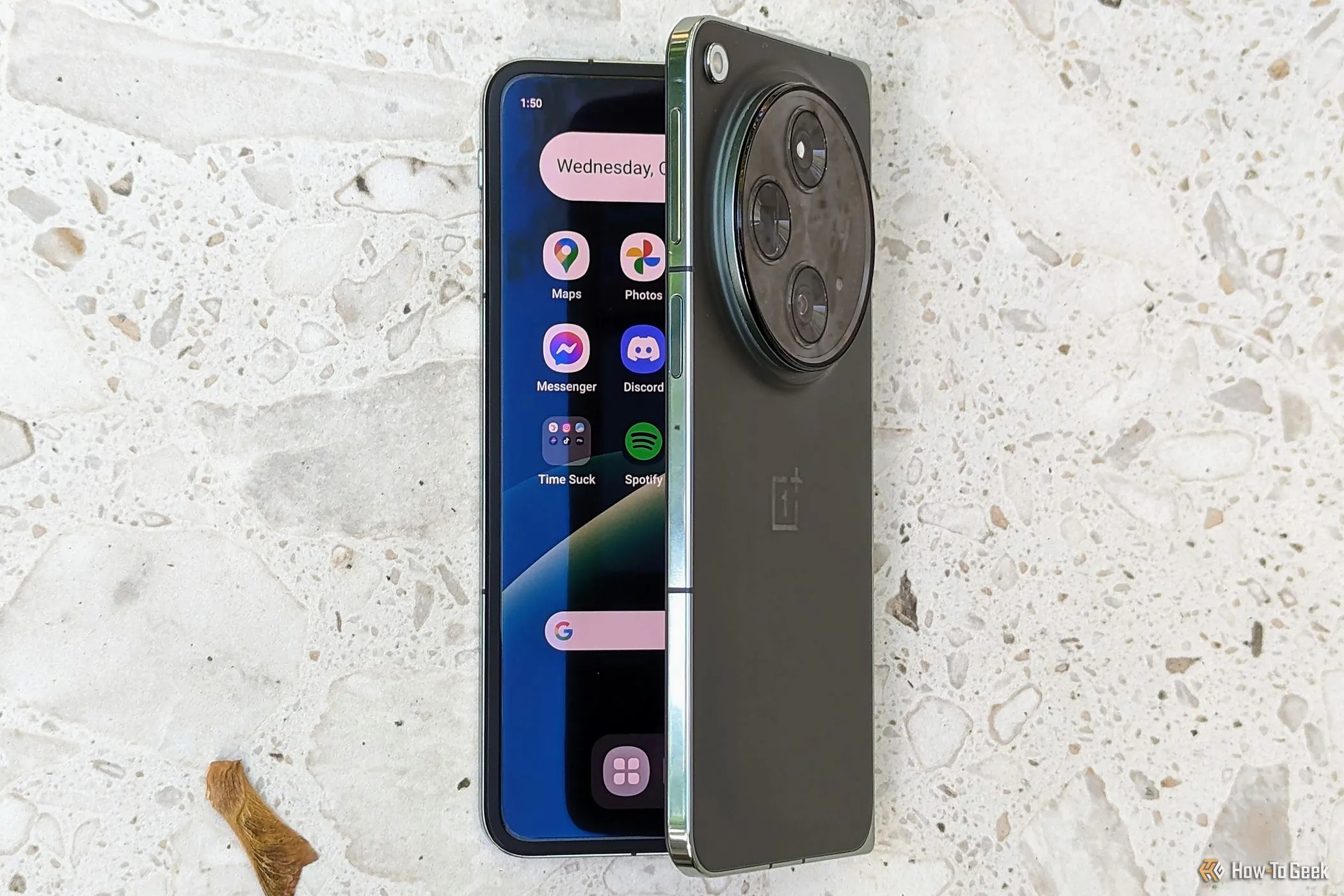Điện thoại gập OnePlus Open đang mở hé trên mặt bàn, thể hiện thiết kế độc đáo của smartphone gập.