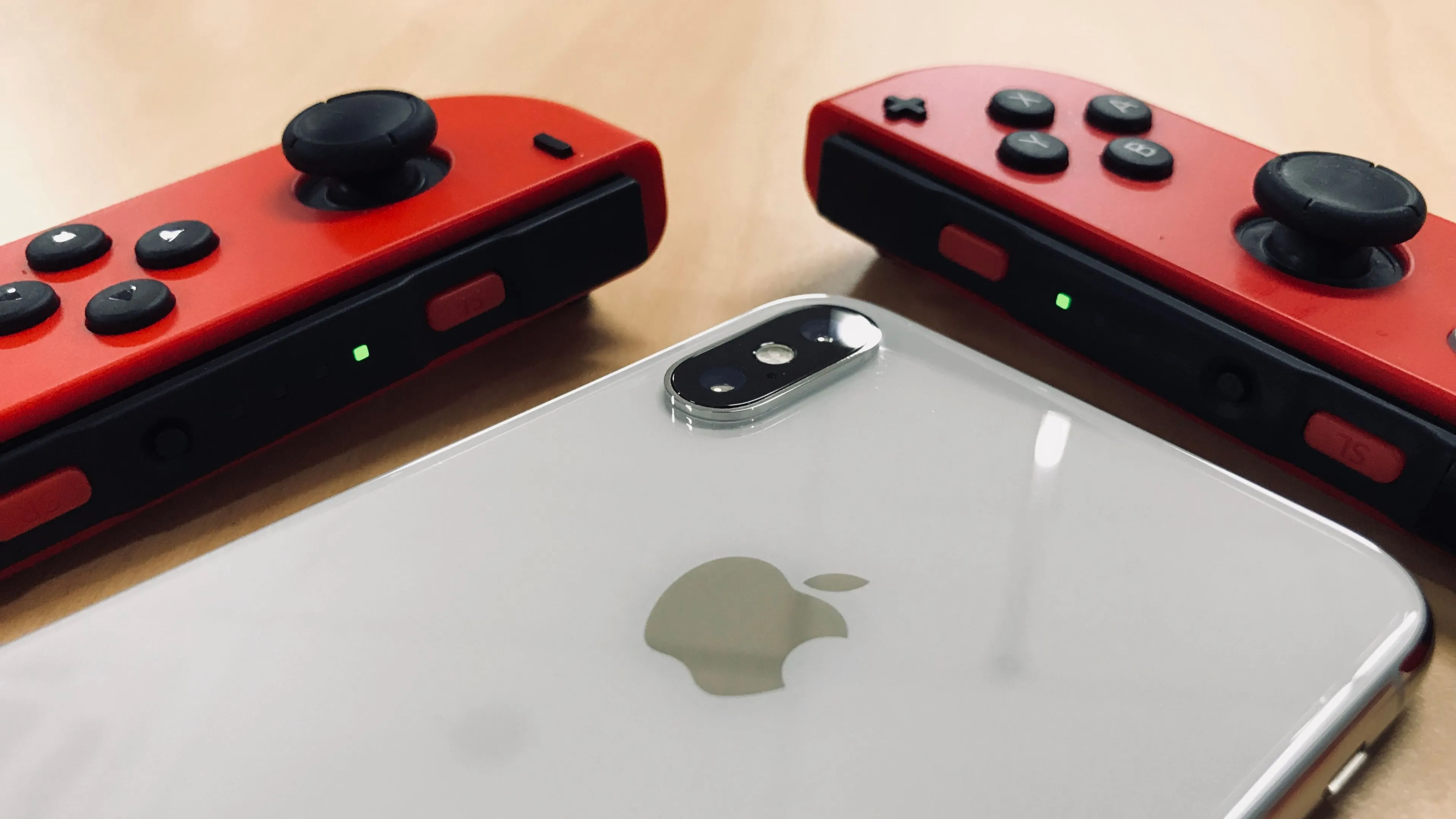 Điện thoại iPhone kết hợp với tay cầm Joy-Con của Nintendo Switch, gợi ý về sự phát triển của game di động và gacha