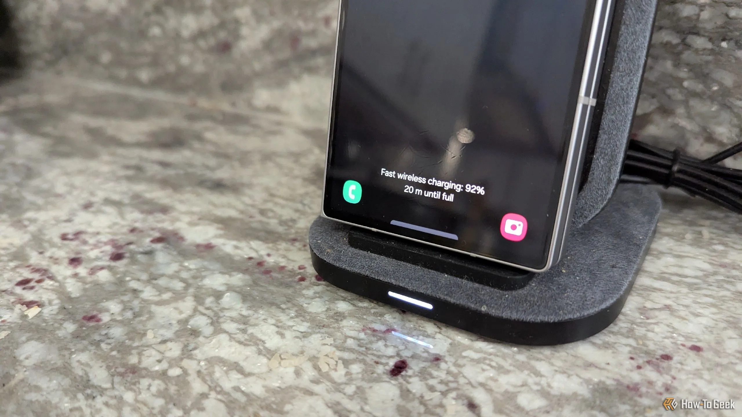 Điện thoại Samsung Galaxy Z Fold 6 đang đặt trên đế sạc không dây dạng đứng, minh họa cách sạc cần cố định thiết bị.