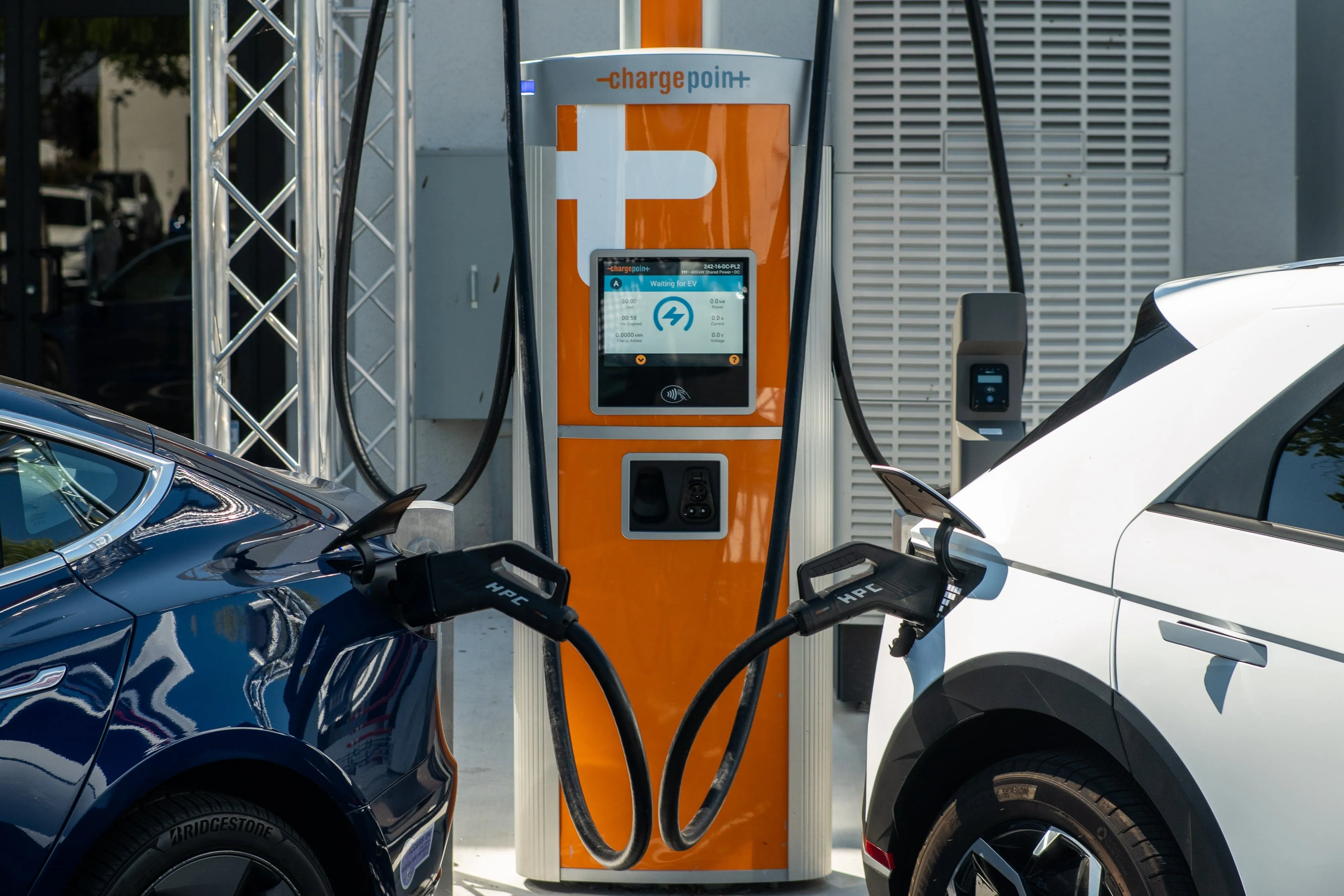 Hai xe điện đang sạc tại trạm sạc ChargePoint với cổng kết nối Omniport tại một trạm sạc công cộng.