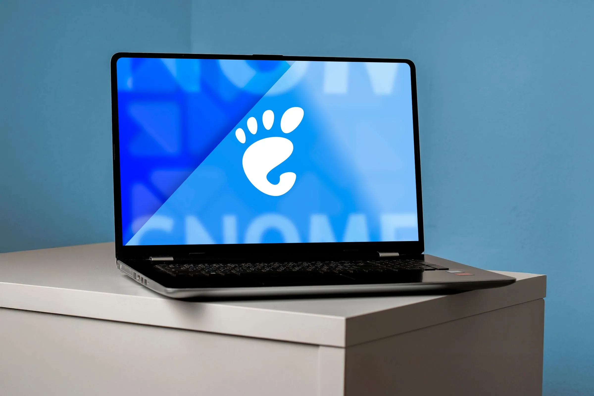 Hình ảnh laptop với logo GNOME trên màn hình, đại diện cho môi trường desktop.