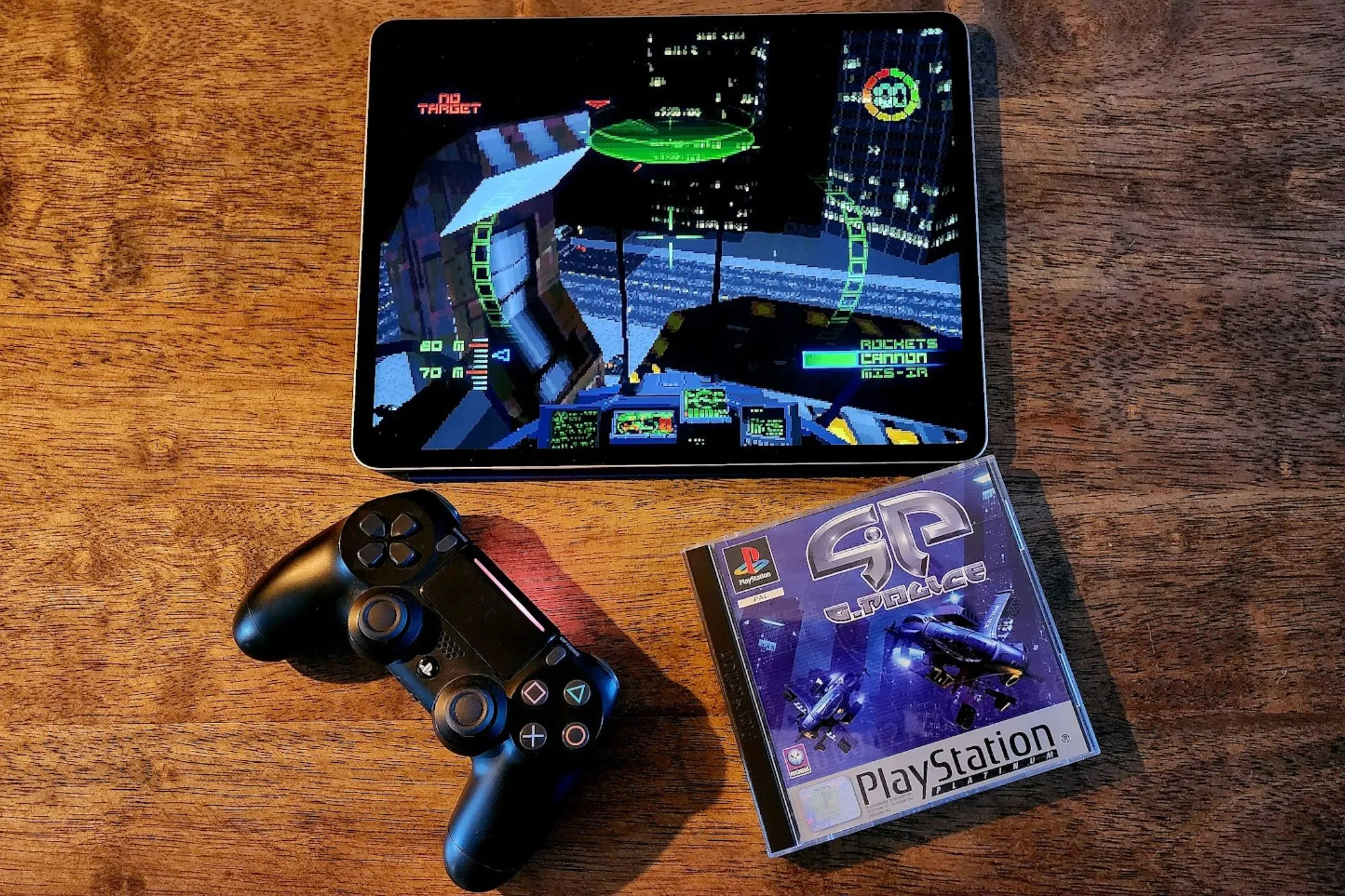 iPad đang chạy game G-Police giả lập cùng đĩa game PS1 gốc và tay cầm PS4