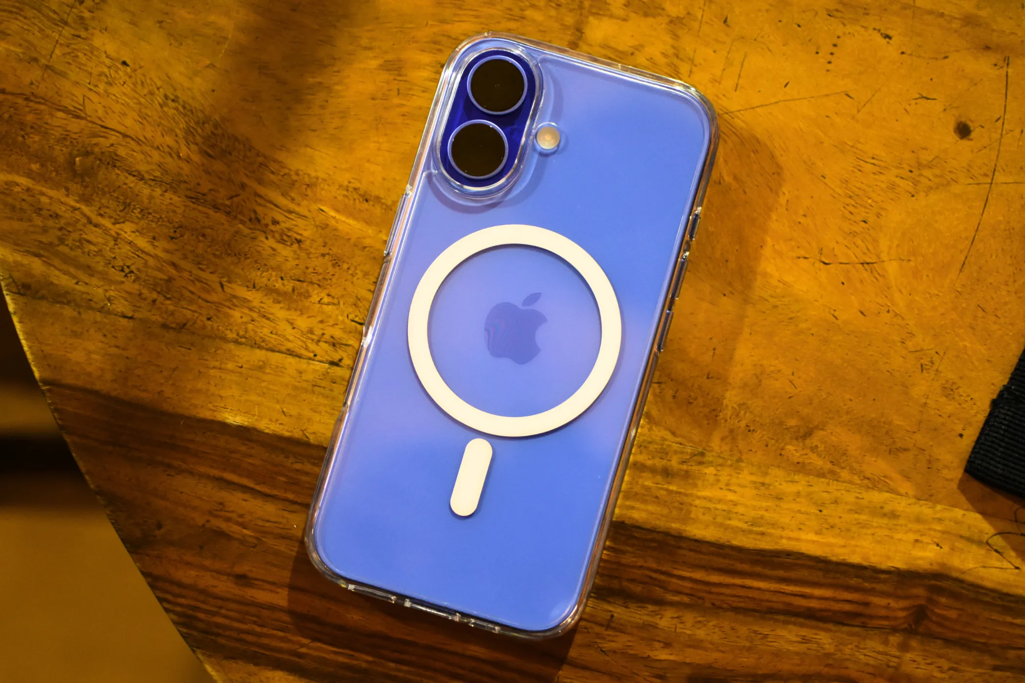 iPhone 16 màu xanh Ultramarine với ốp MagSafe trong suốt, nổi bật cụm camera kép