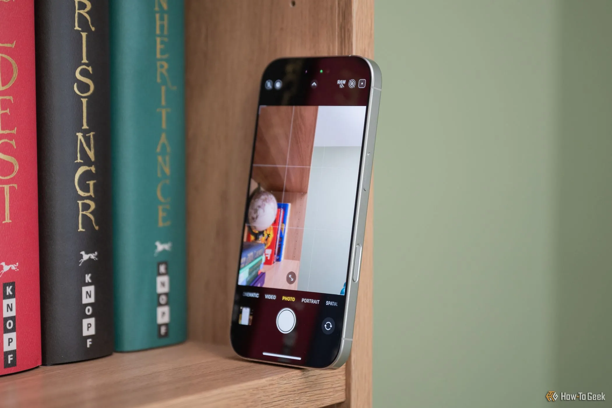 iPhone 16 Pro đặt trên kệ, màn hình hiển thị giao diện điều khiển camera chuyên nghiệp