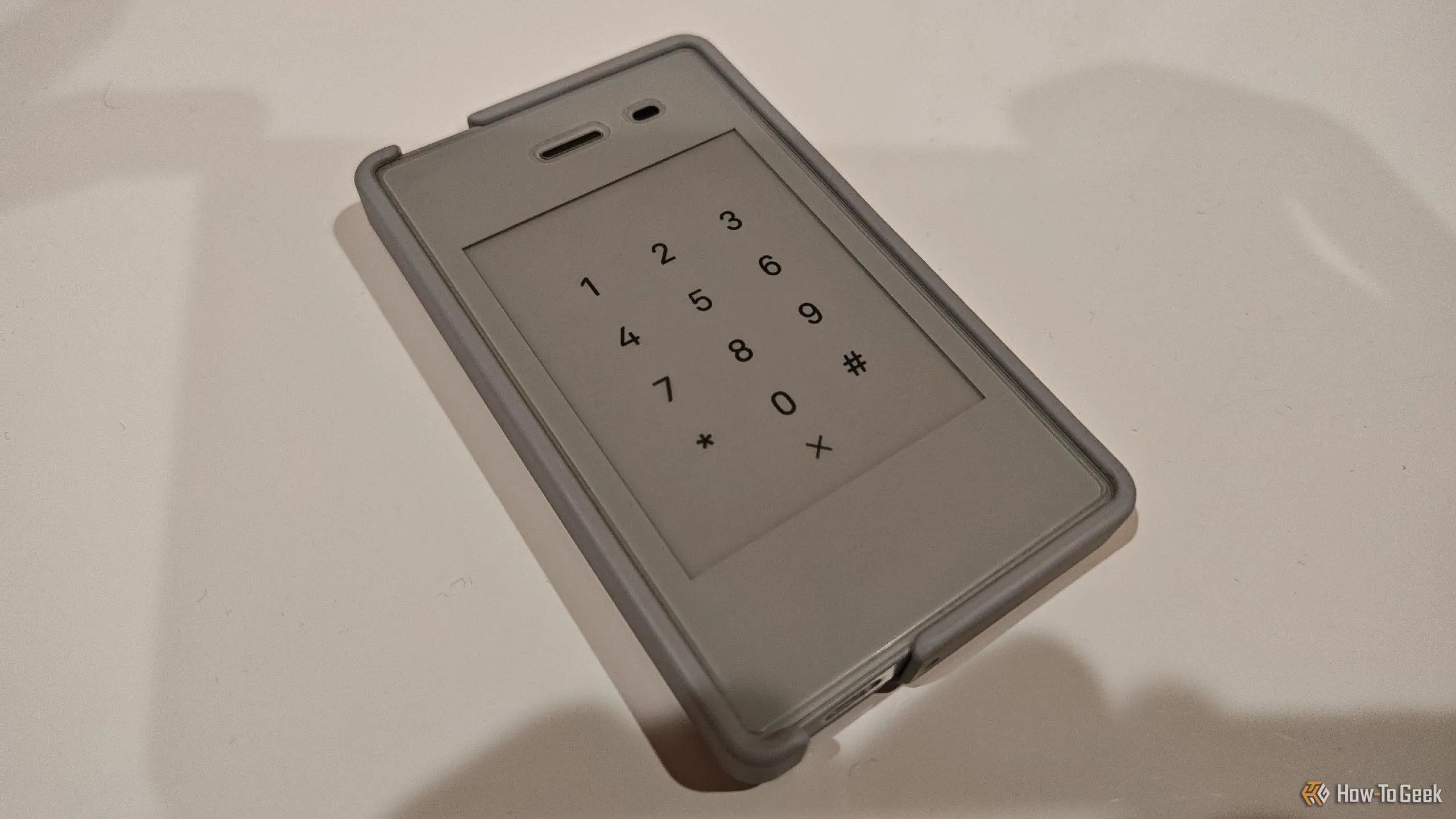 Light Phone 2 đặt trên bề mặt màu trắng, thể hiện thiết kế tối giản của một chiếc điện thoại cục gạch.