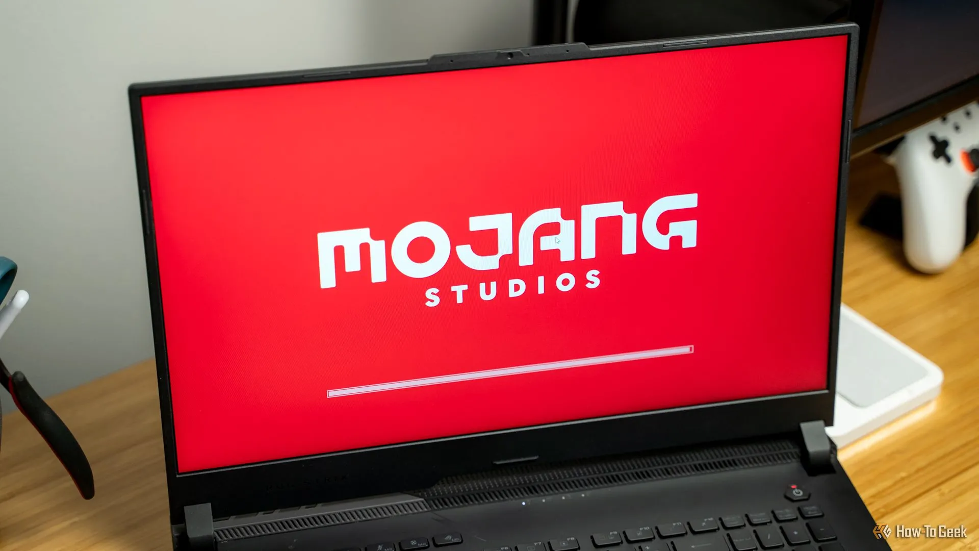 Logo Mojang Studios và giao diện khởi chạy Minecraft trên laptop