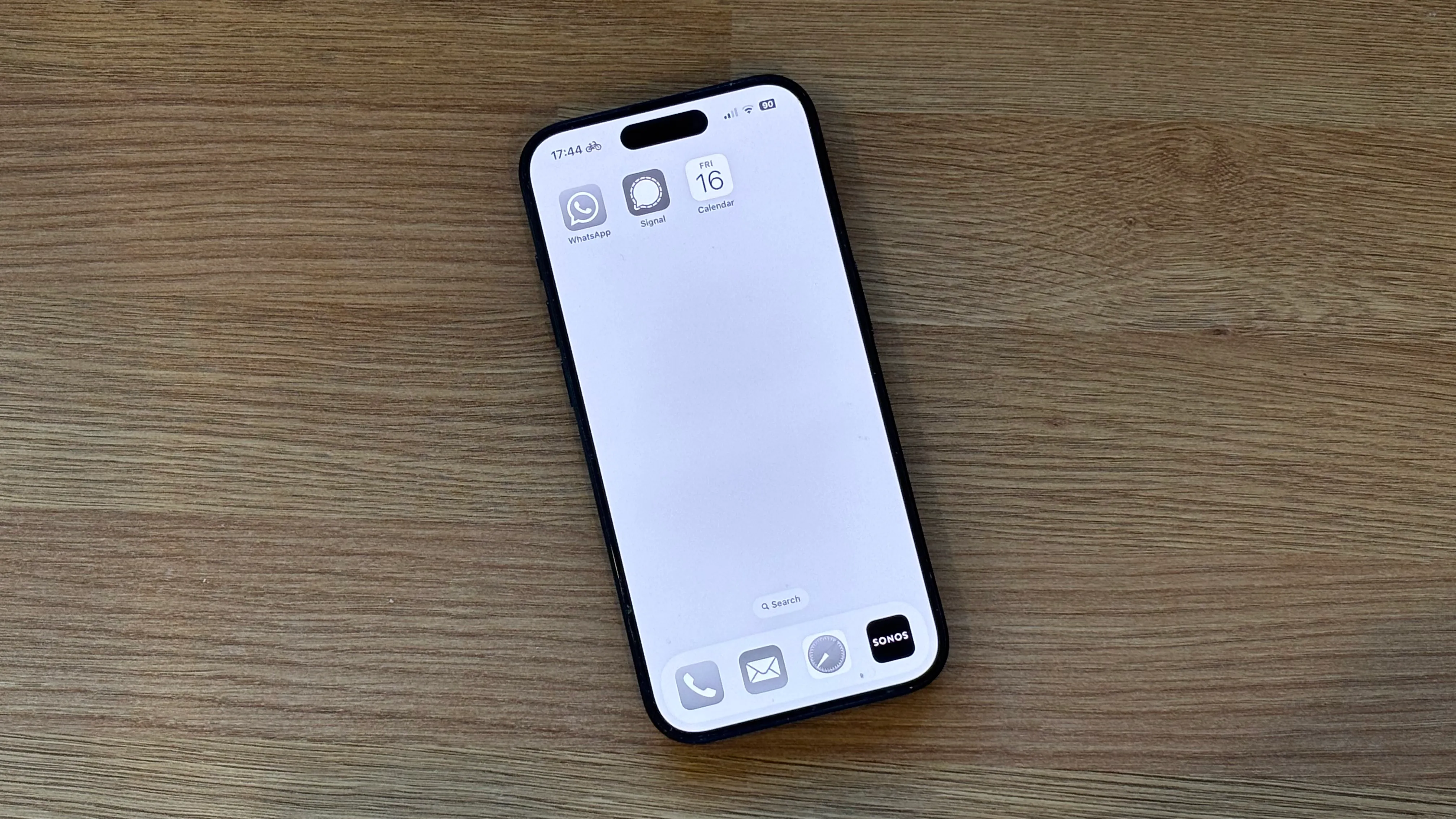 Màn hình chính iPhone ở chế độ thang độ xám (grayscale) với ba biểu tượng ứng dụng, làm giảm sự hấp dẫn thị giác