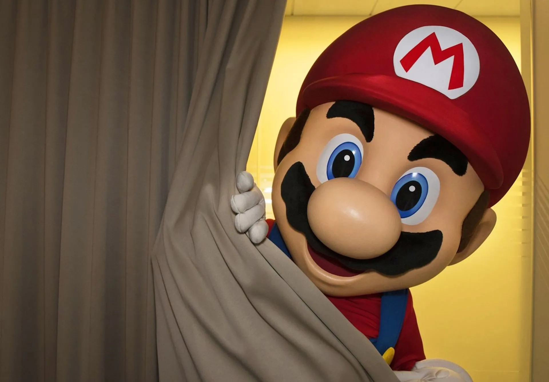 Mario lén lút nhìn từ sau bức màn, ám chỉ sự kiện ra mắt Nintendo NX bí ẩn