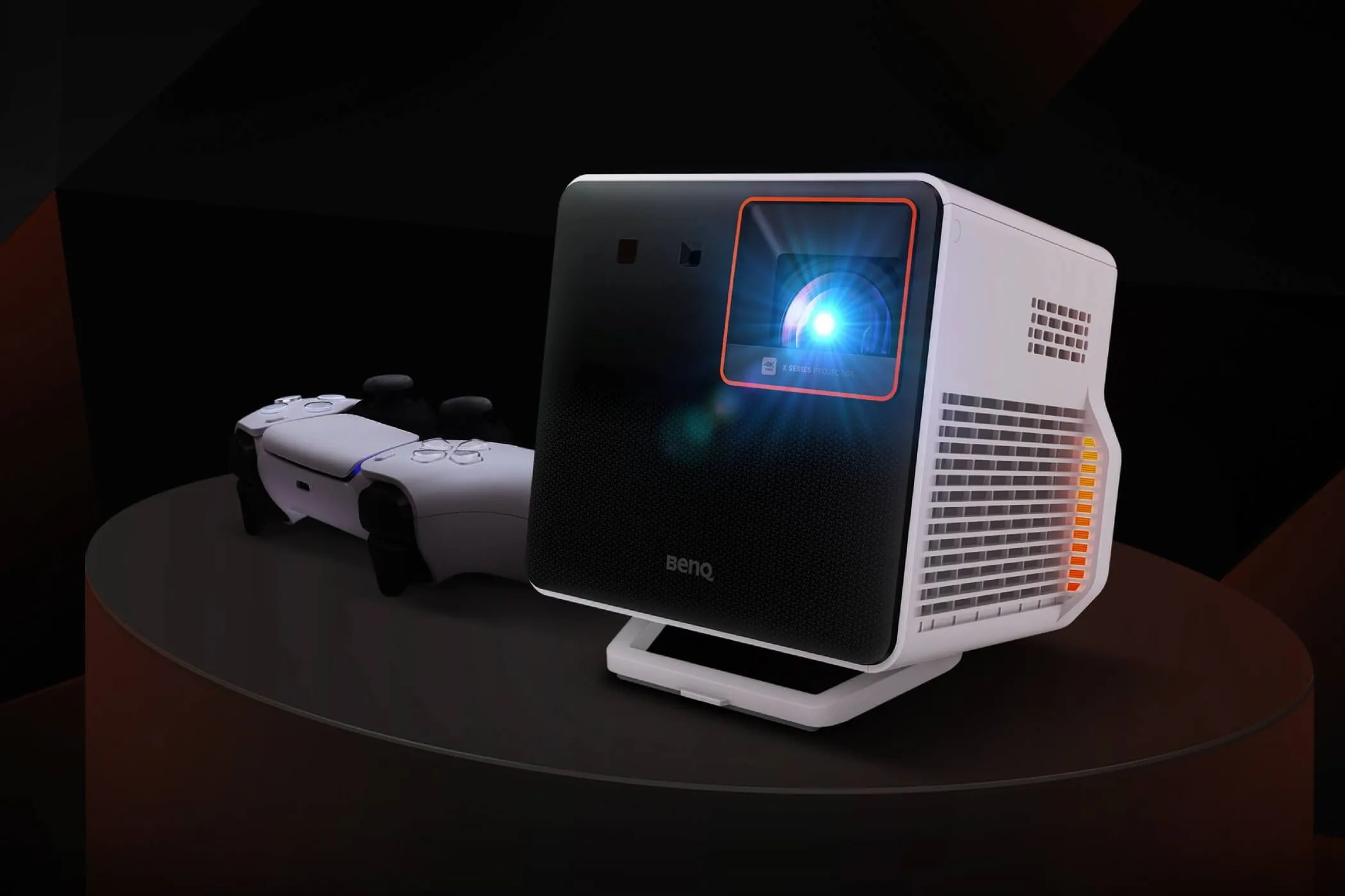 Máy chiếu BenQ X300G màu trắng đen đặt trên bàn cạnh một cuốn sổ và bút