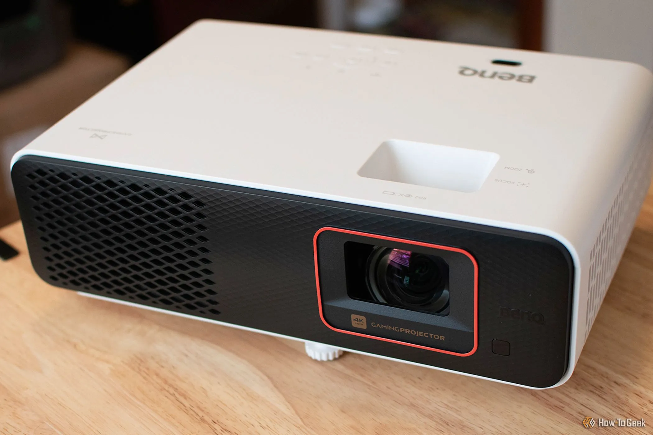 Máy chiếu BenQ X500i màu trắng đặt trên bàn, hướng về phía trước