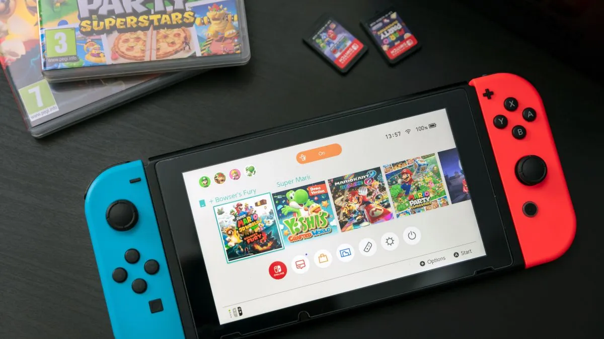Máy chơi game Nintendo Switch đặt trên bàn cùng hai hộp băng game, minh họa khả năng quản lý dữ liệu lưu game độc lập.