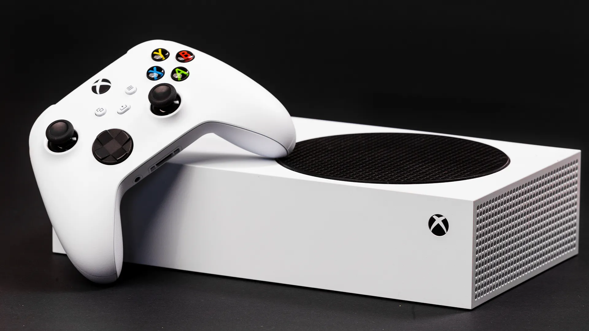 Máy chơi game Xbox Series S màu trắng đặt ngang với bộ điều khiển