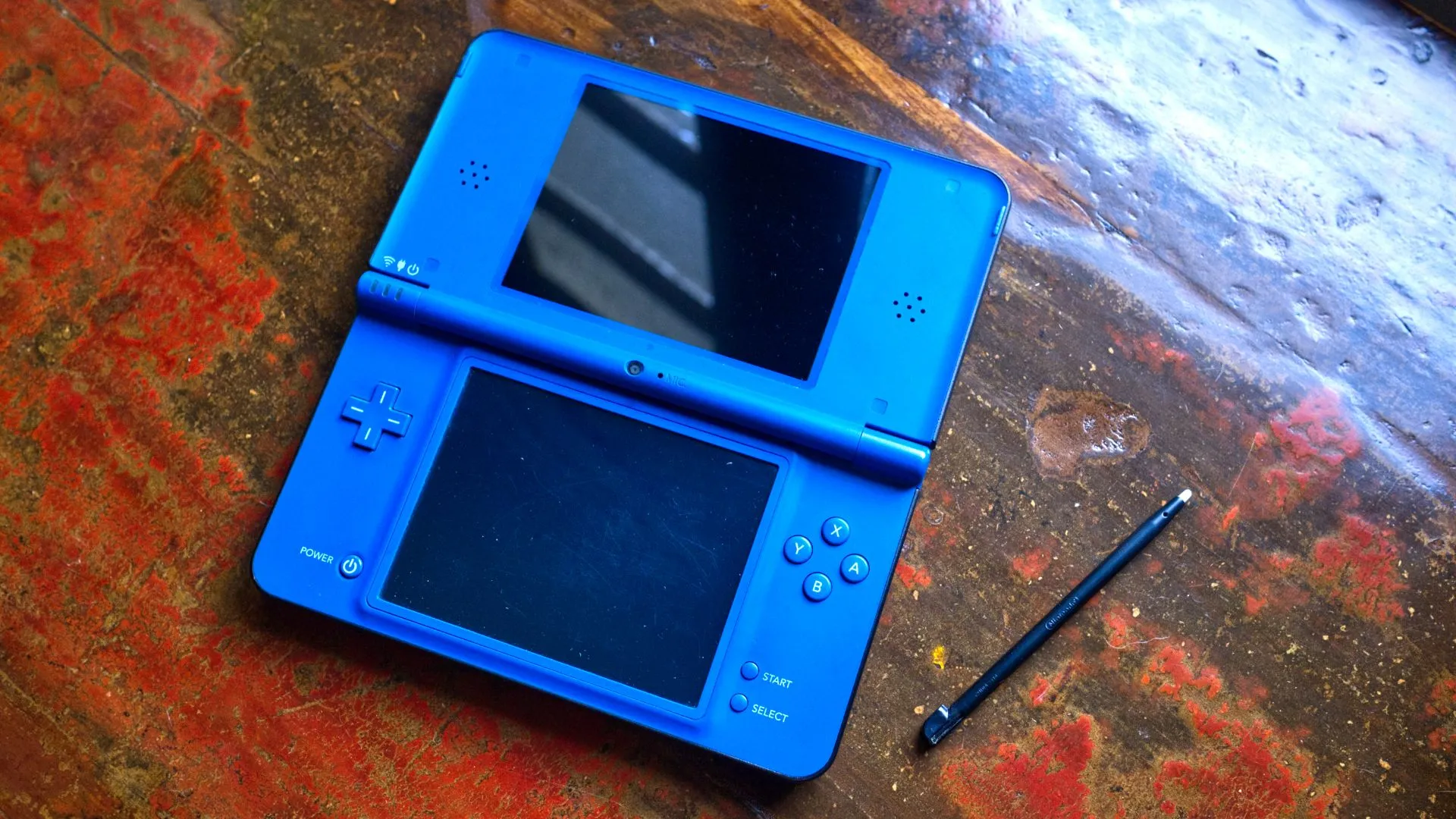 Máy Nintendo DSi XL màu xanh mở ra với bút cảm ứng