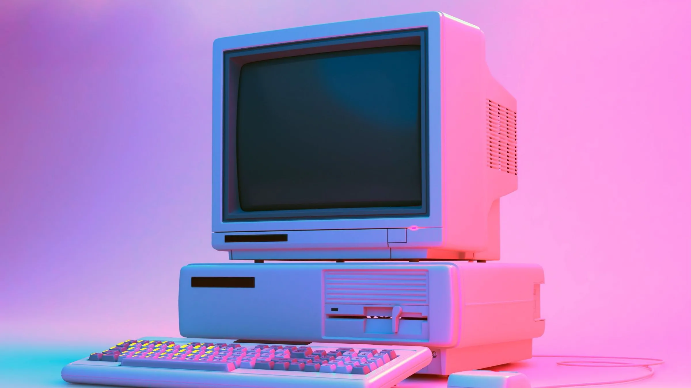 Máy tính để bàn cổ điển với ổ đĩa mềm, bàn phím và chuột trong ánh sáng Neon.