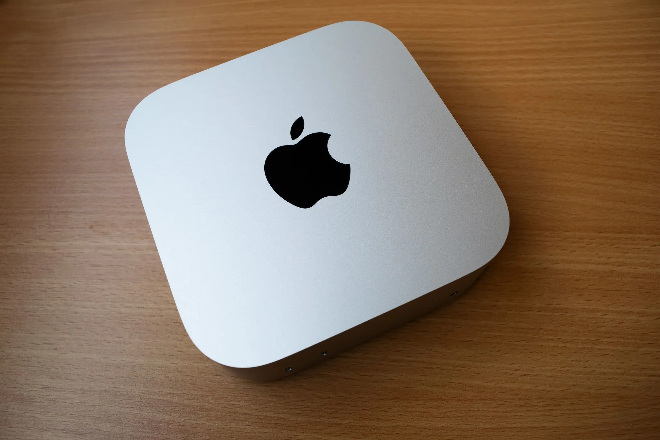 Máy tính mini Apple Mac Mini M4 đặt trên bàn gỗ, thể hiện thiết kế nhỏ gọn và hiệu năng mạnh mẽ.