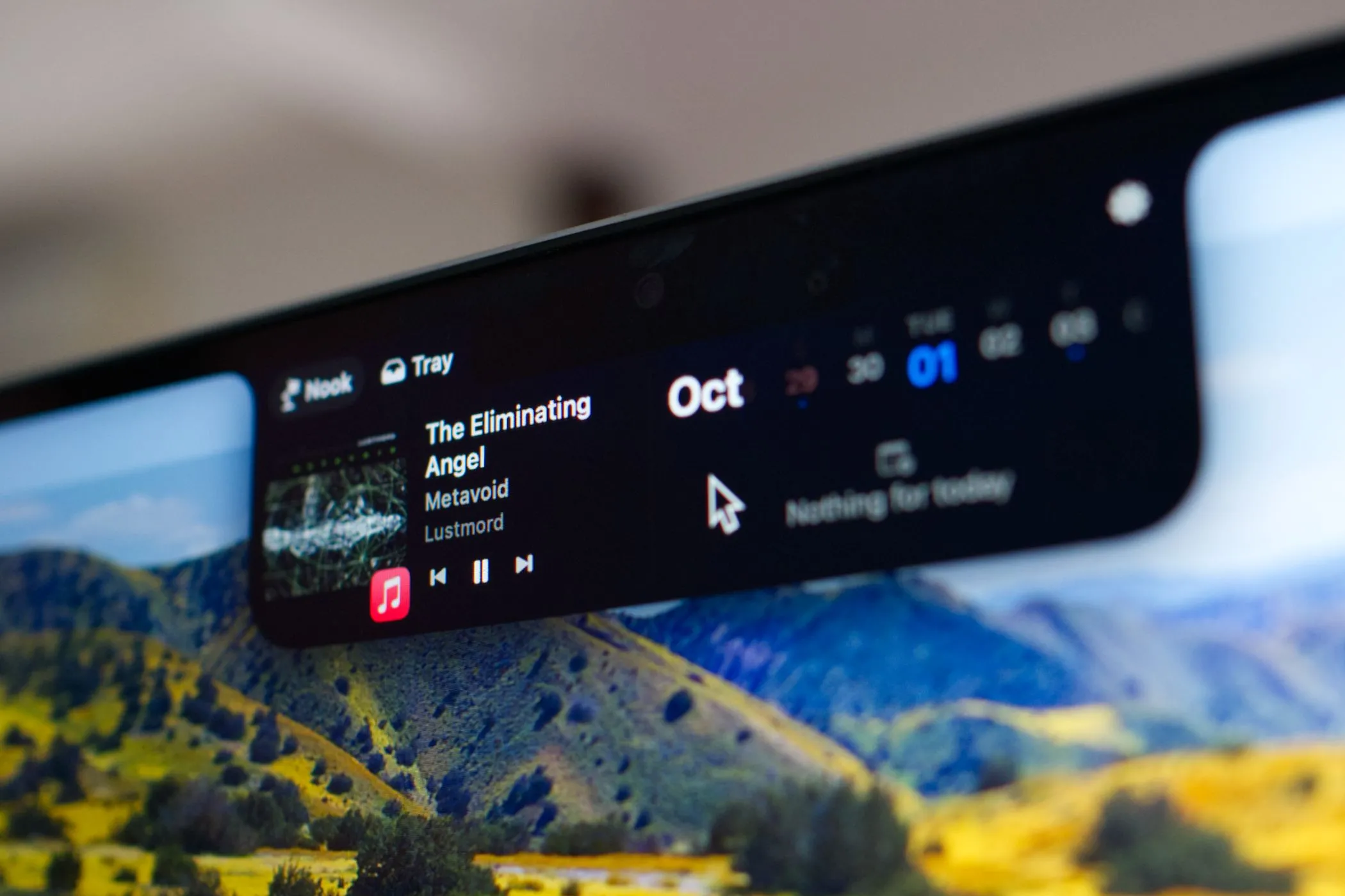 Mô hình MacBook Pro với notch đang chạy ứng dụng NotchNook, hiển thị các tính năng mở rộng xung quanh notch